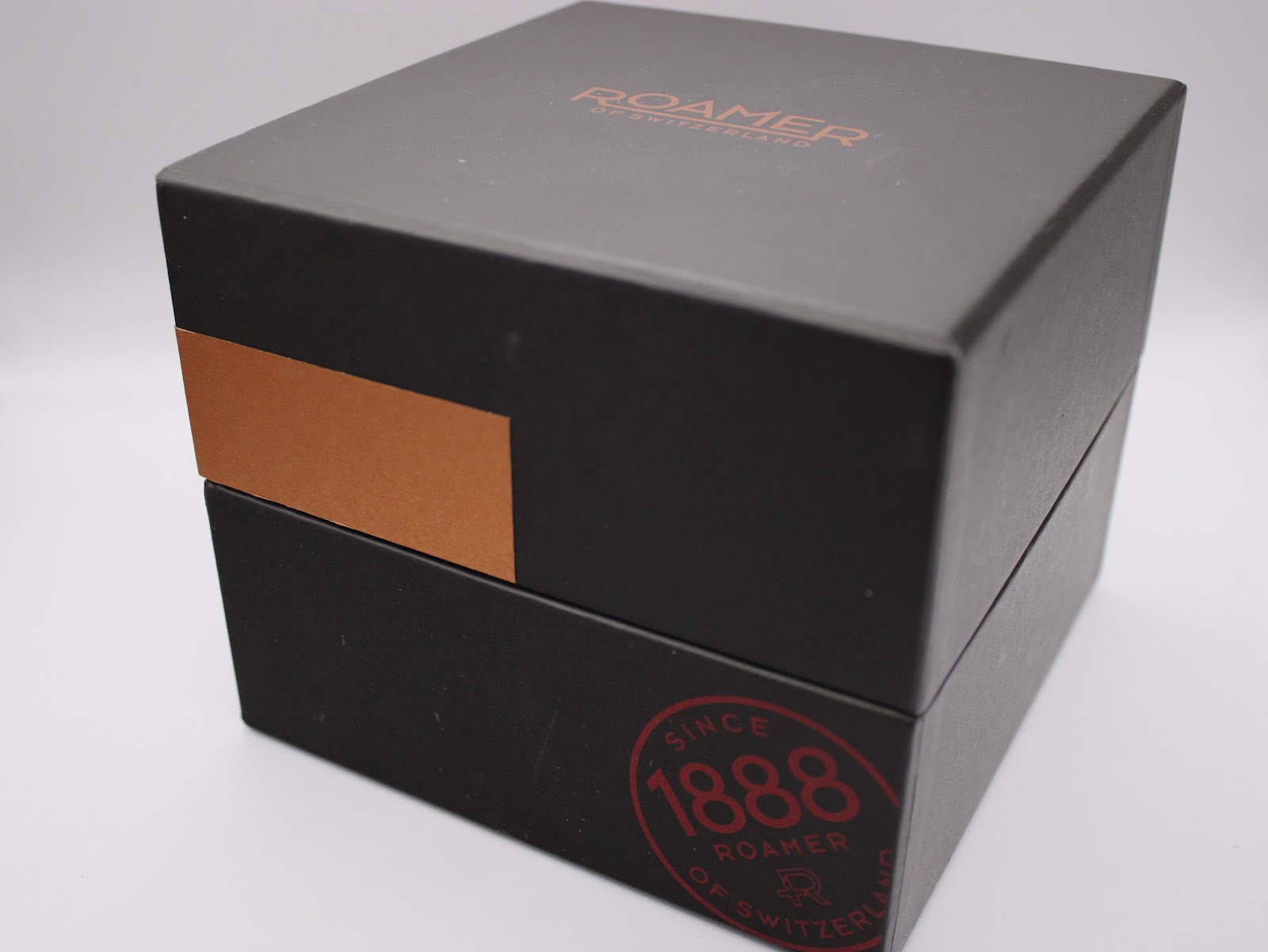 Exterior view of the black Roamer branded presentation box with a brown accent band.