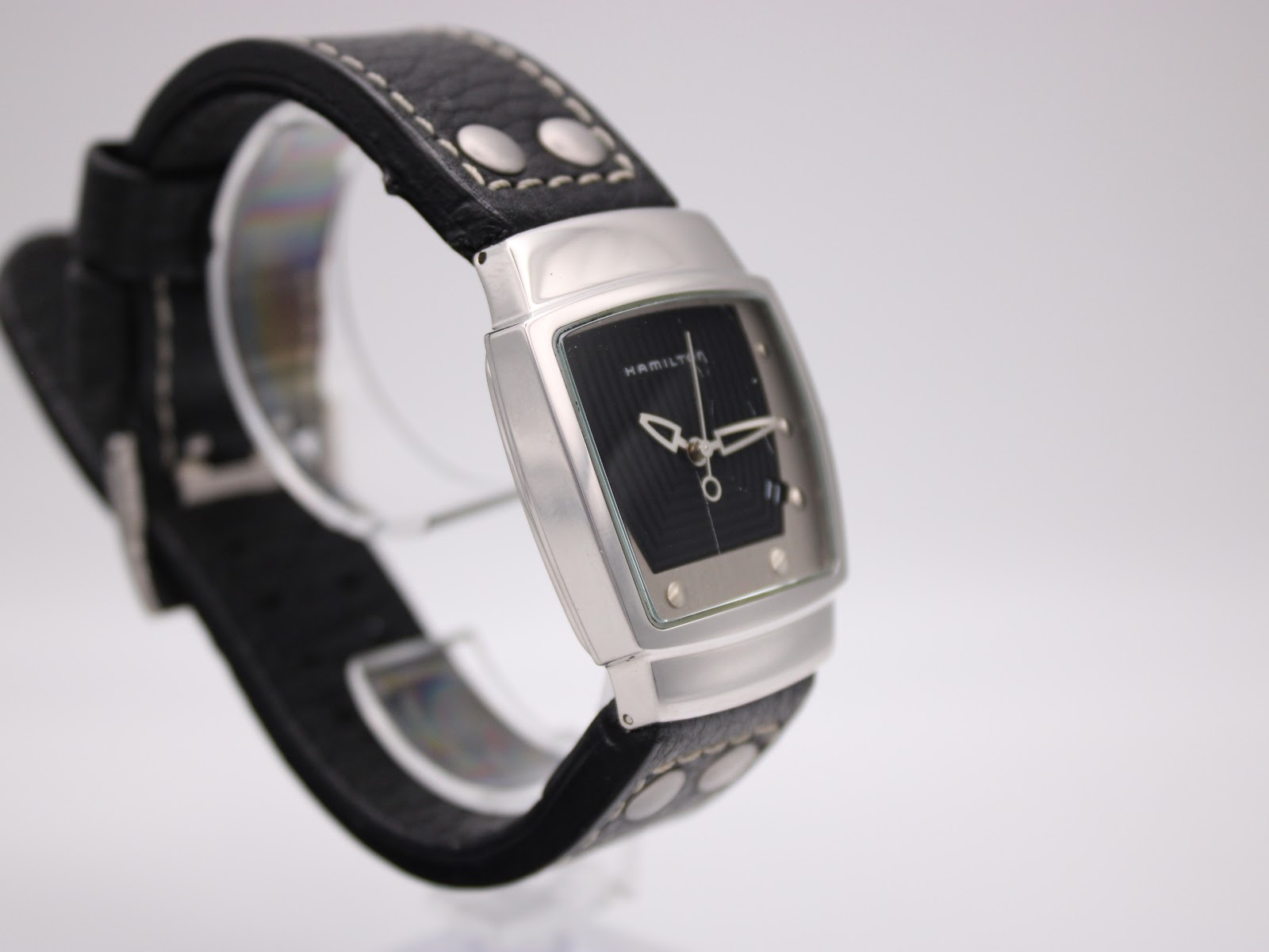 Another angled side view of the Hamilton H163110 watch, highlighting the case shape and black leather strap.