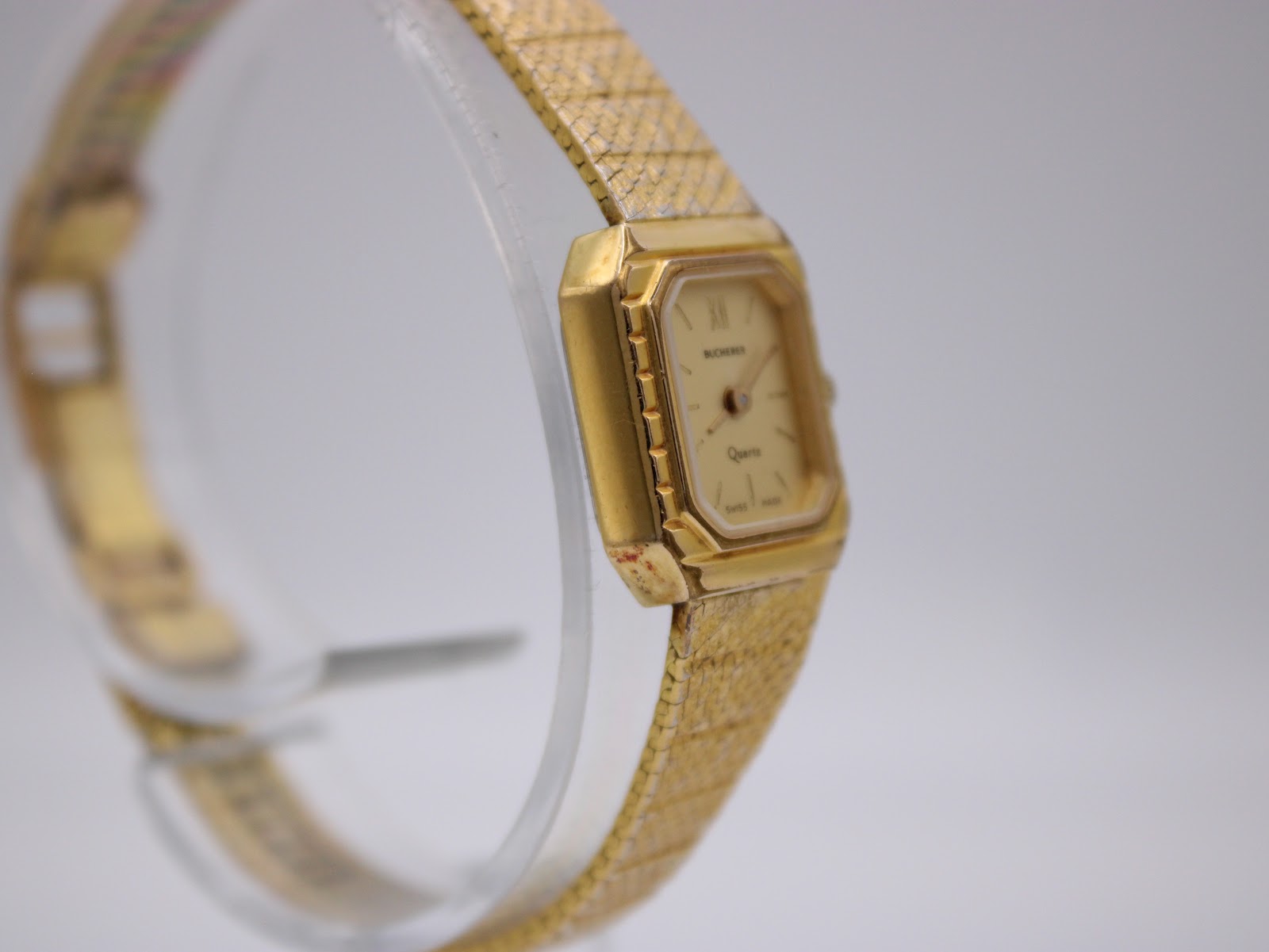 Close-up side view of the Bucherer watch on a stand, showing the crown and case profile.