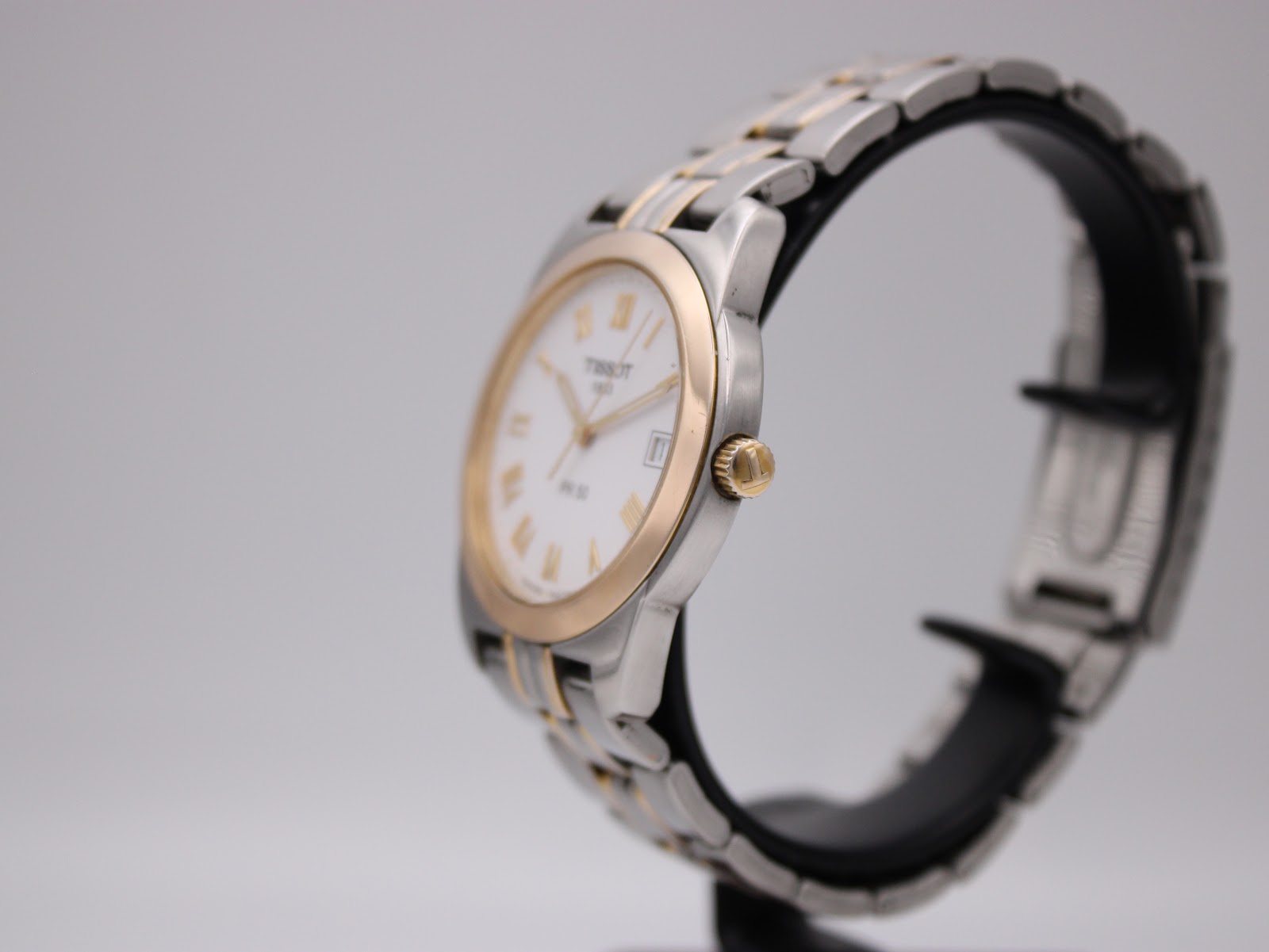 Angled side view of the Tissot PR 50 watch, showing the crown and two-tone bracelet.