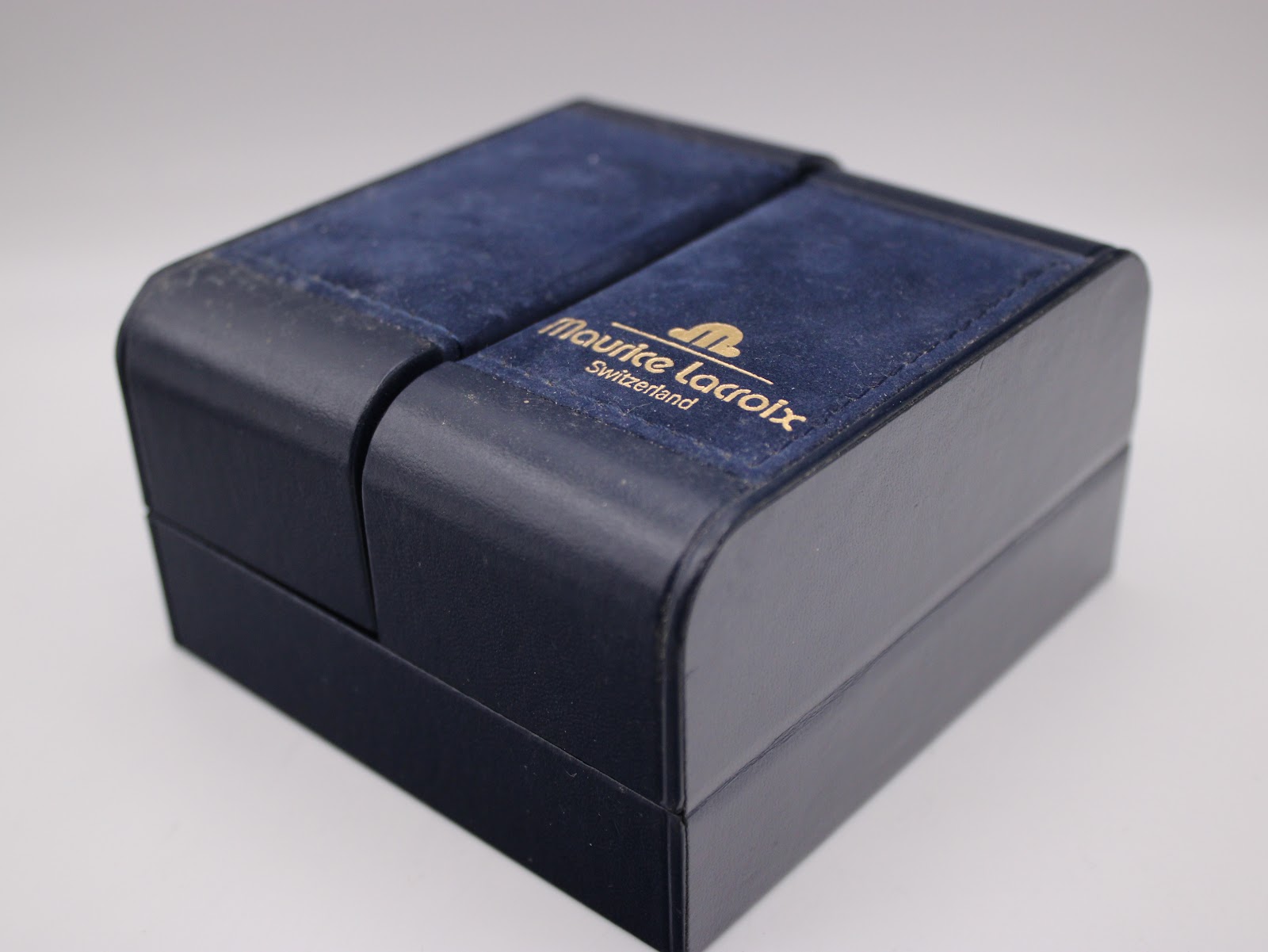 Exterior view of the navy blue Maurice Lacroix presentation box with gold lettering.