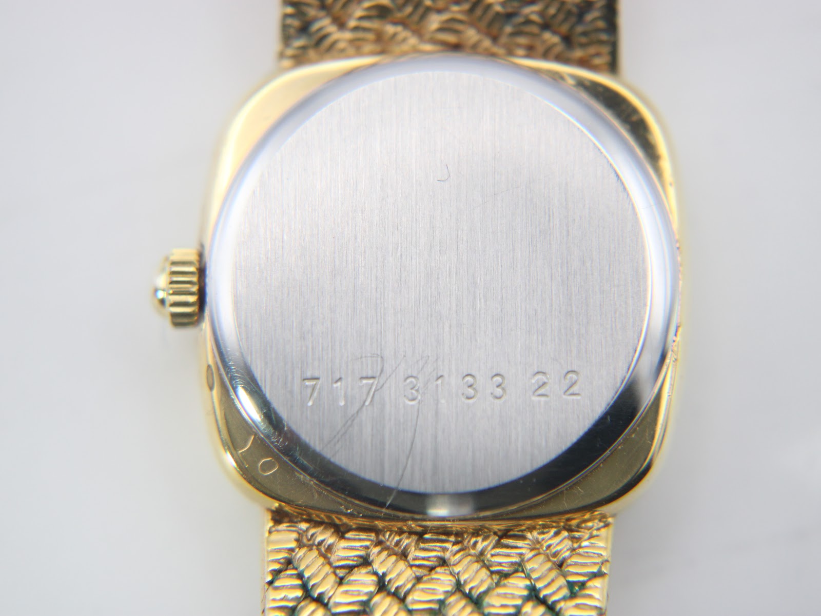 Close-up of the brushed stainless steel case back of the Certina watch, showing the serial number '717 3133 22' engraved.