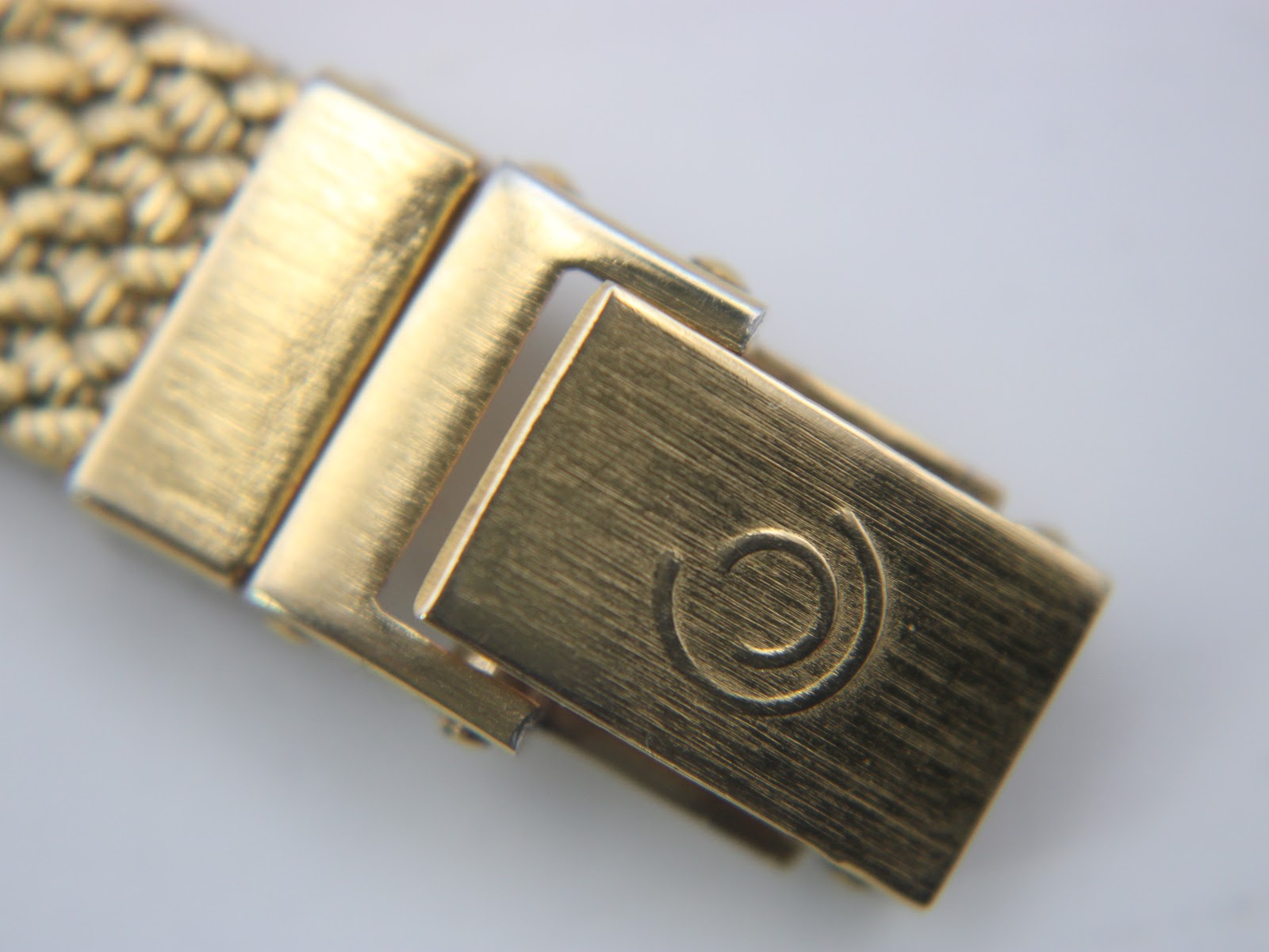 Close-up of the gold-tone fold-over clasp on the mesh bracelet, featuring the embossed Certina 'double C' logo.