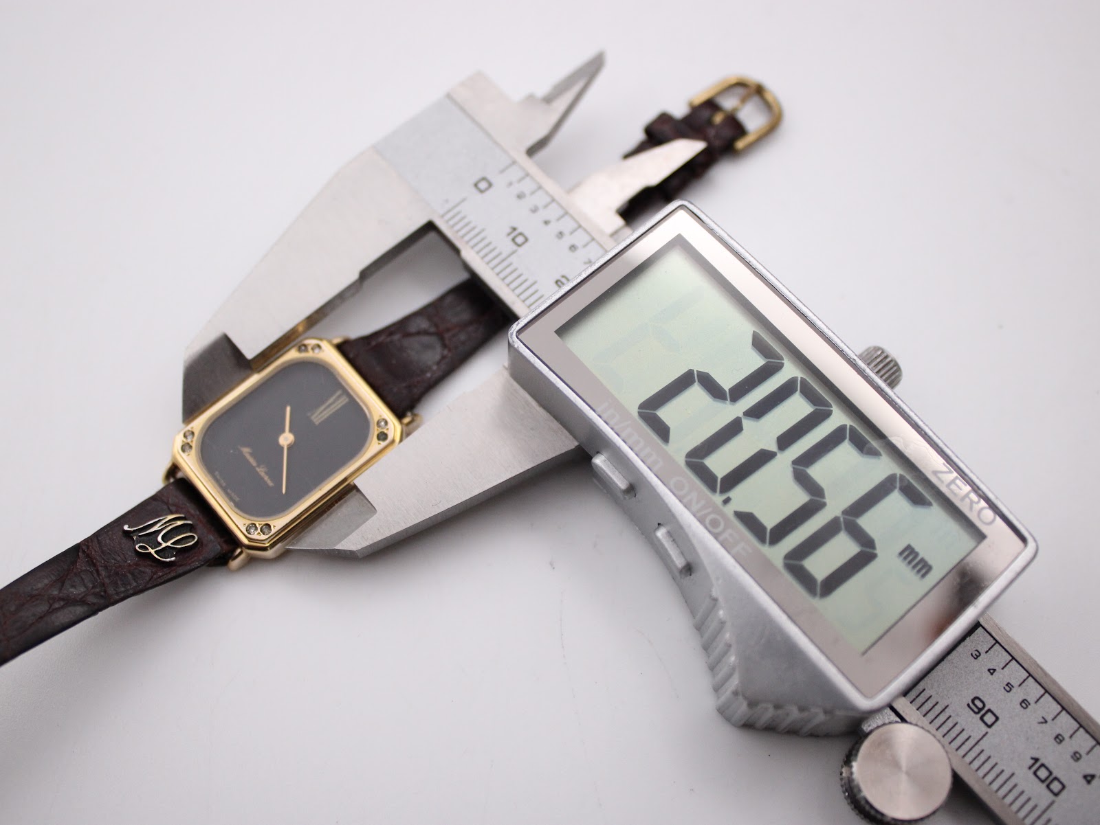 Digital caliper measuring the width of the watch case, displaying a precise measurement of 20.66mm.