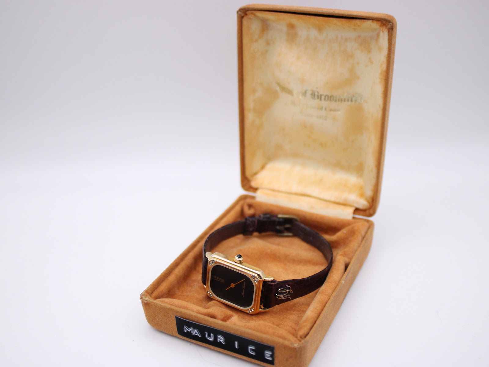The Maurice Lacroix watch elegantly presented inside its vintage brown velvet-covered original presentation box with the 'Maurice' label.