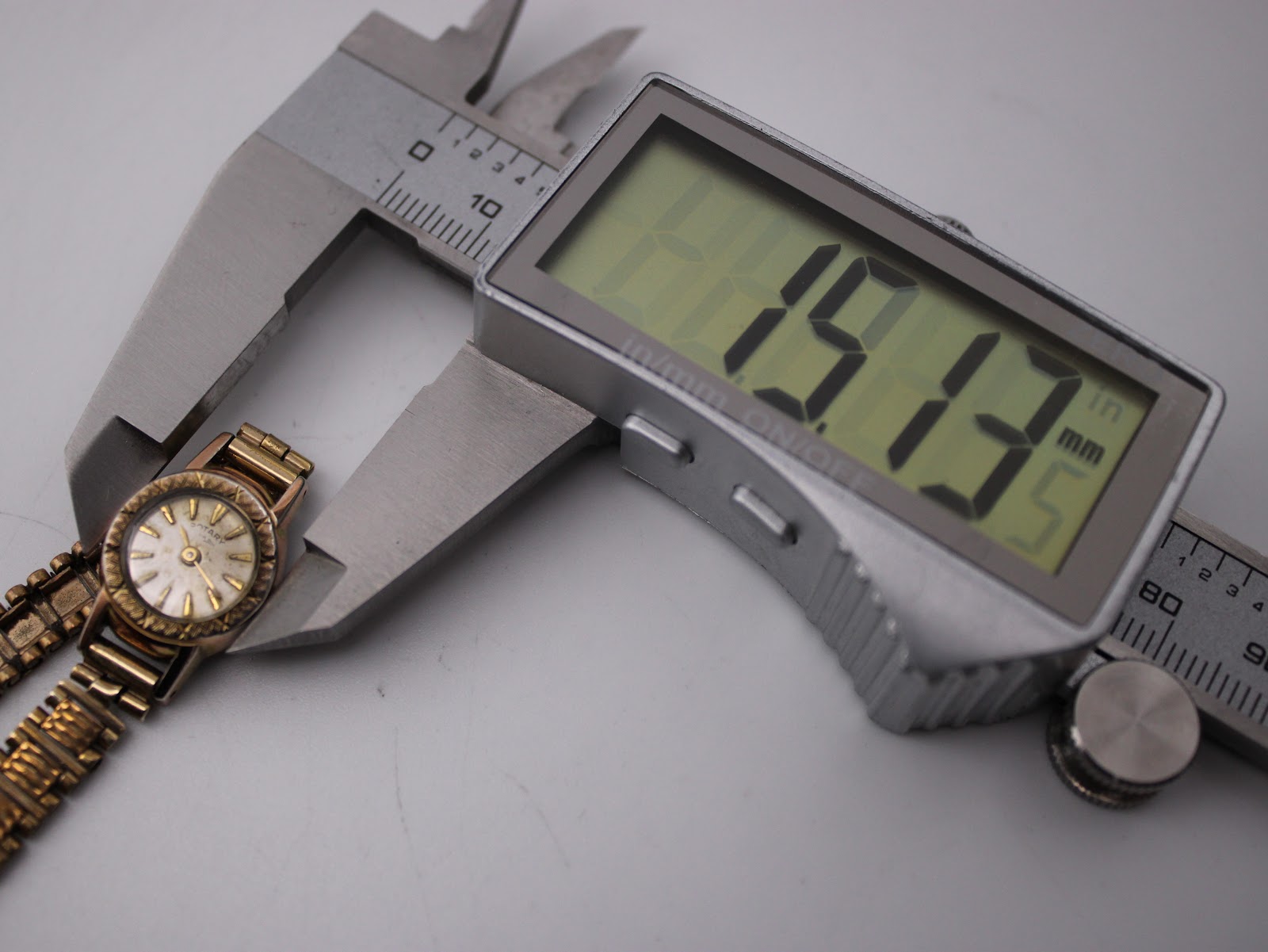 Digital caliper measuring the watch case diameter at 19.13mm.
