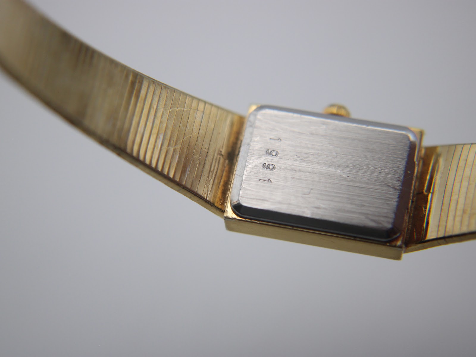 Close-up of the watch case back, clearly showing the engraved serial number '1991'.