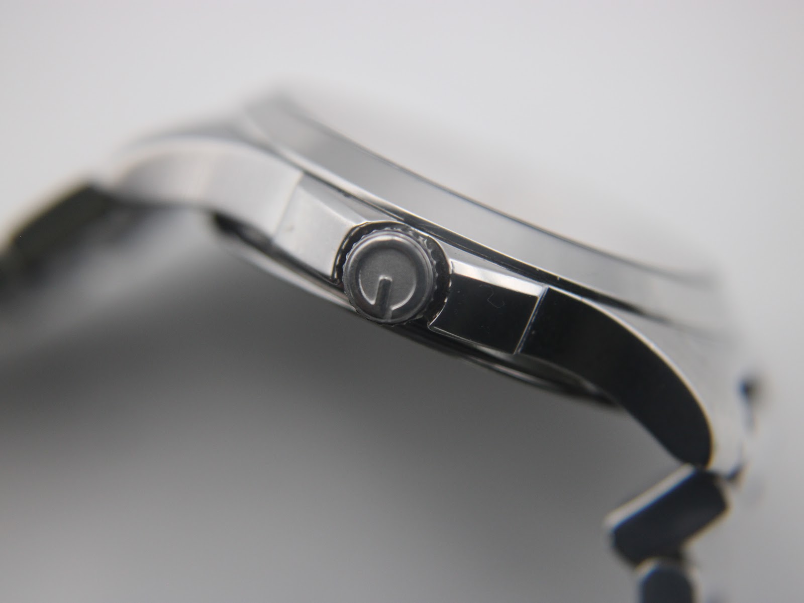 Macro shot of the watch crown, featuring the embossed Gucci 'G' logo.