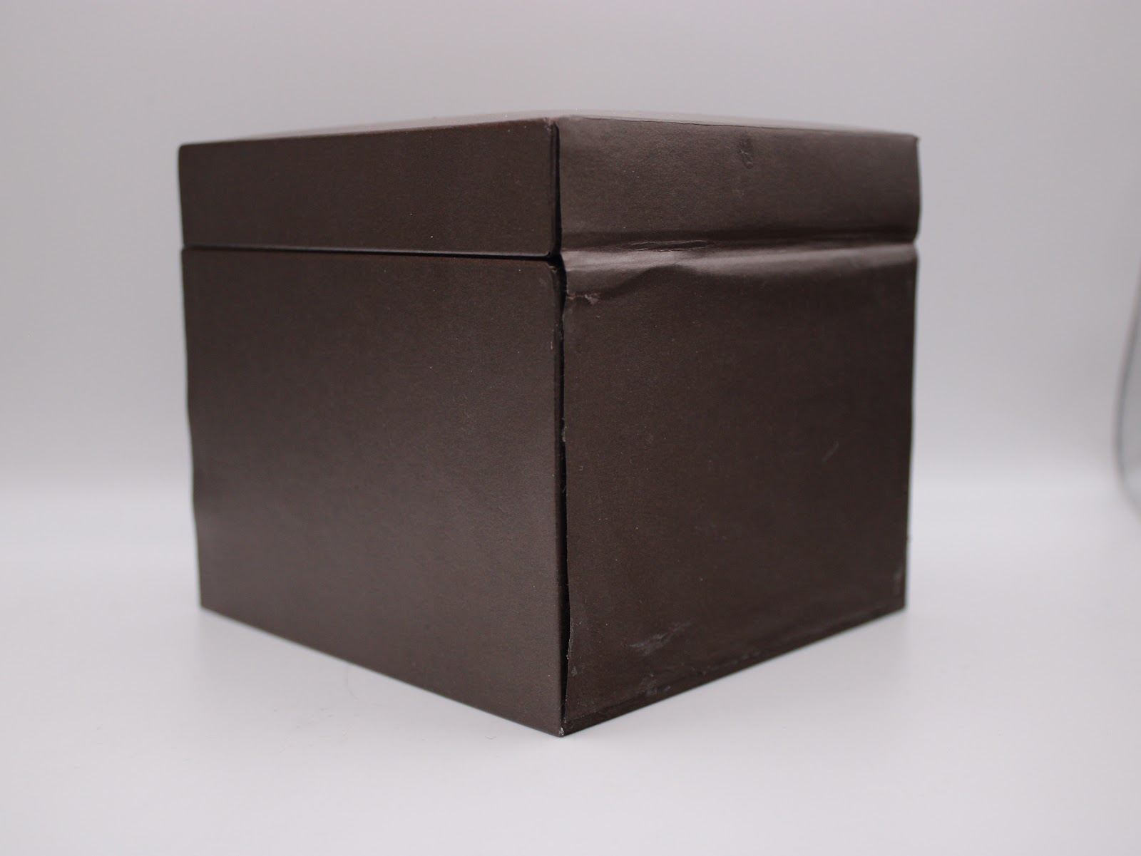 Side view of the closed brown Gucci presentation box, showing its textured finish.