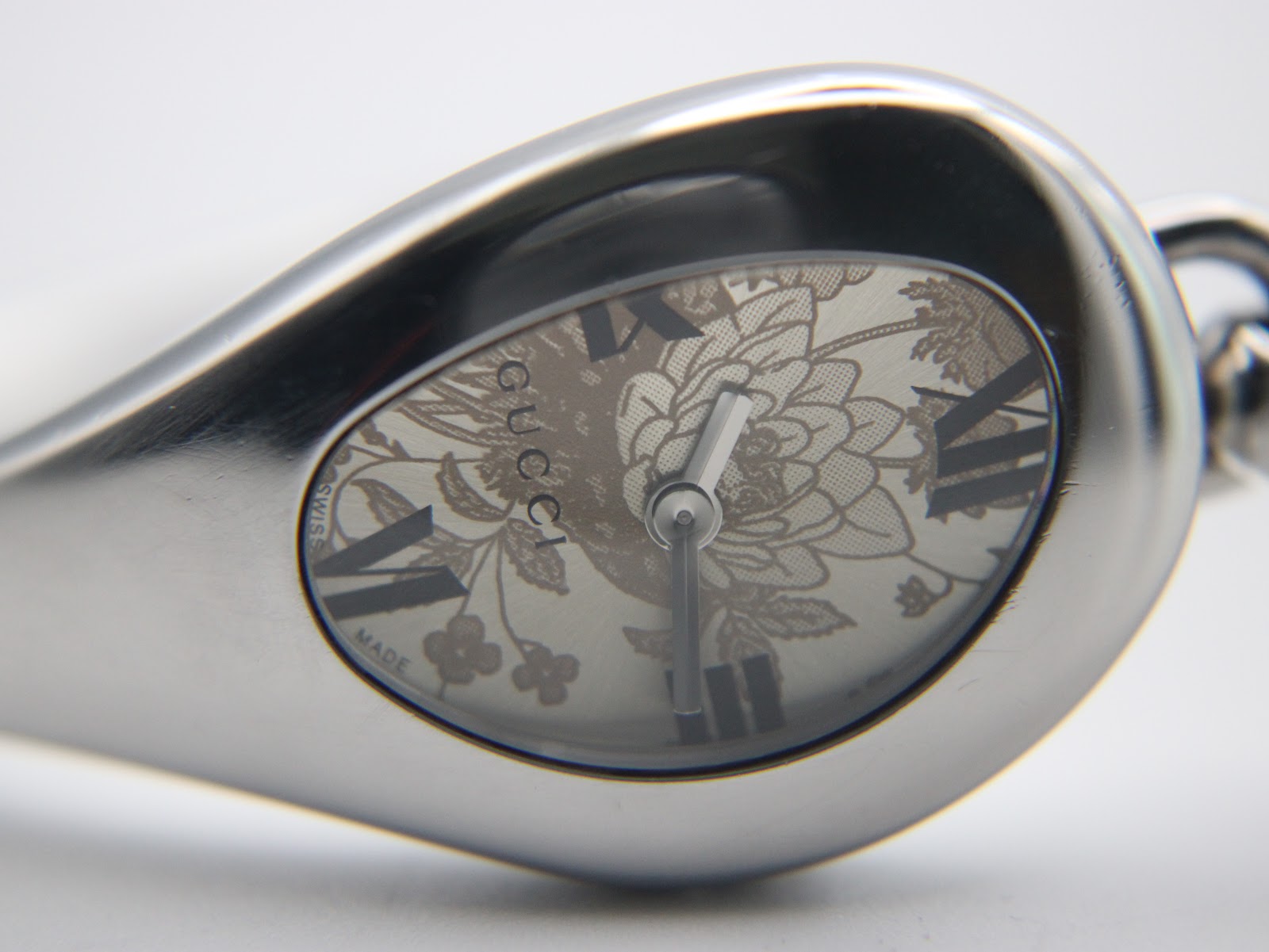 Detailed close-up of the Gucci 103 cream dial with floral pattern and Roman numerals.