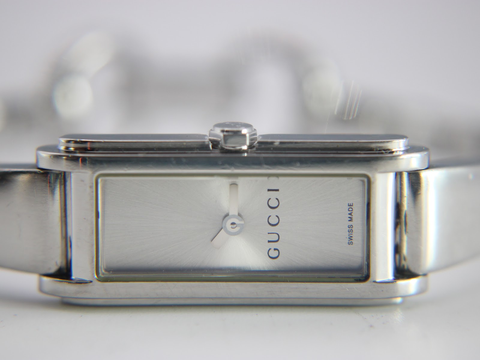 Close-up of the rectangular silver dial with a sunburst finish, 'GUCCI' logo, and 'SWISS MADE' text.
