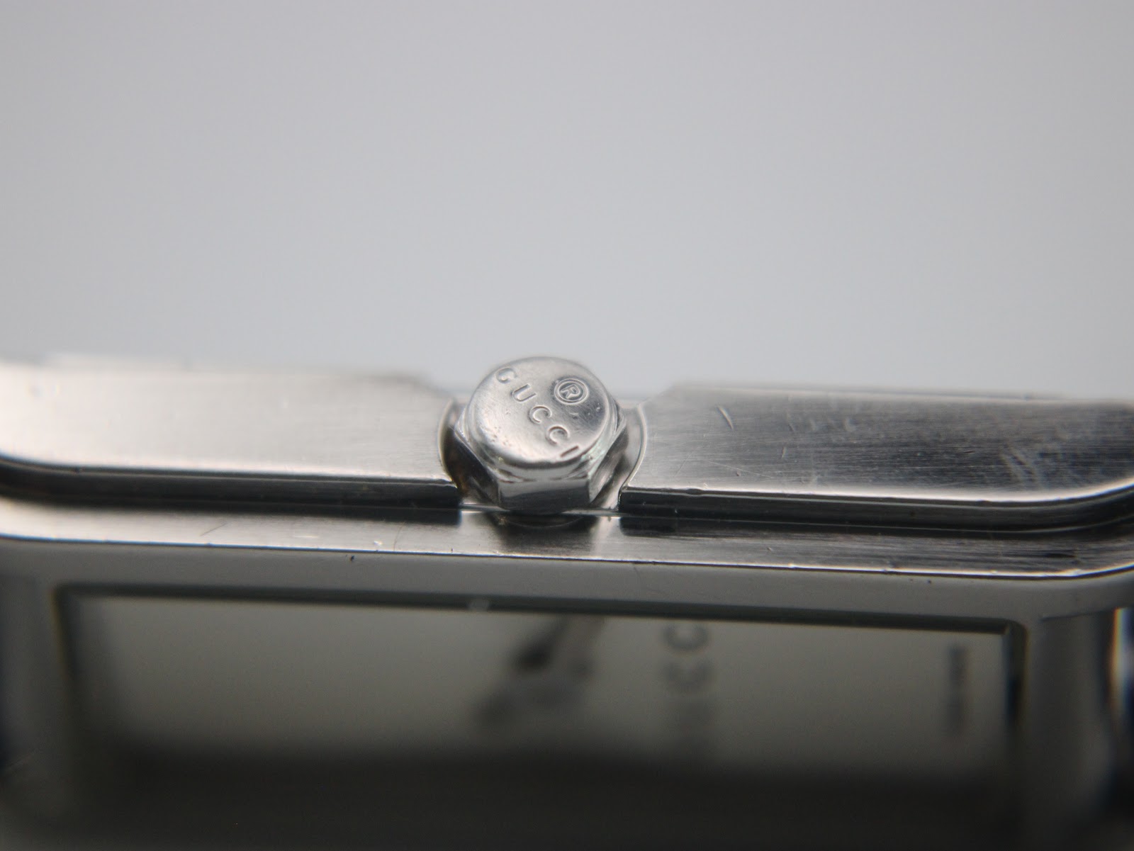 Close-up of the polished crown, subtly embossed with a small 'GUCCI' logo.