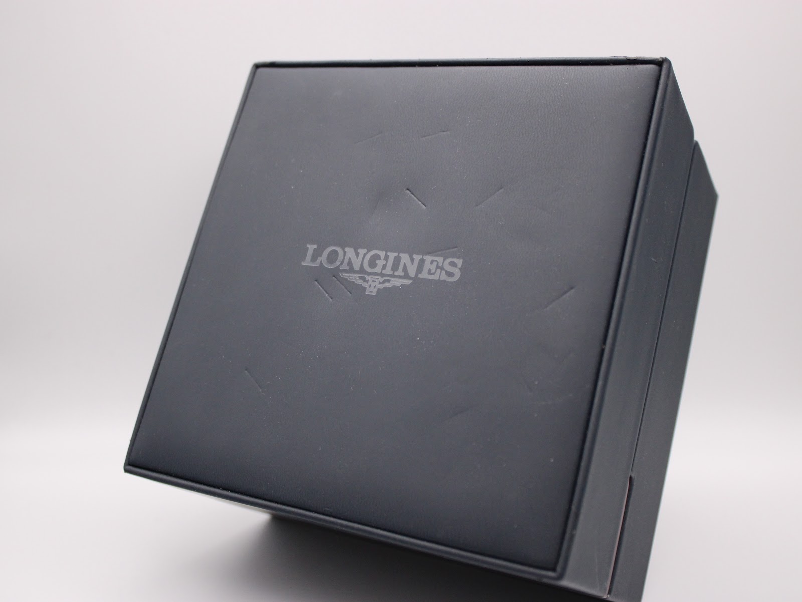Top view of the closed original Longines presentation box, with the brand's logo embossed on the lid.