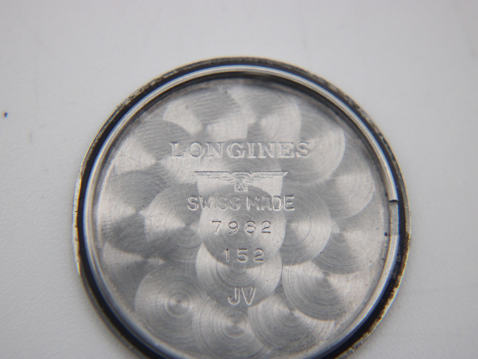 Inside view of the case back after movement removal, showing 'Longines Swiss Made' engraving and internal markings.