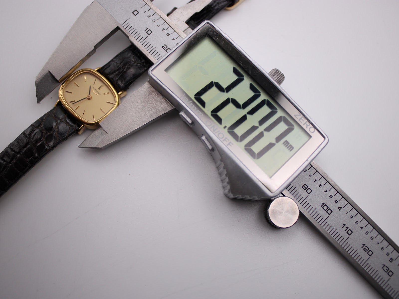Digital caliper measuring the watch case diameter at 22.00mm.