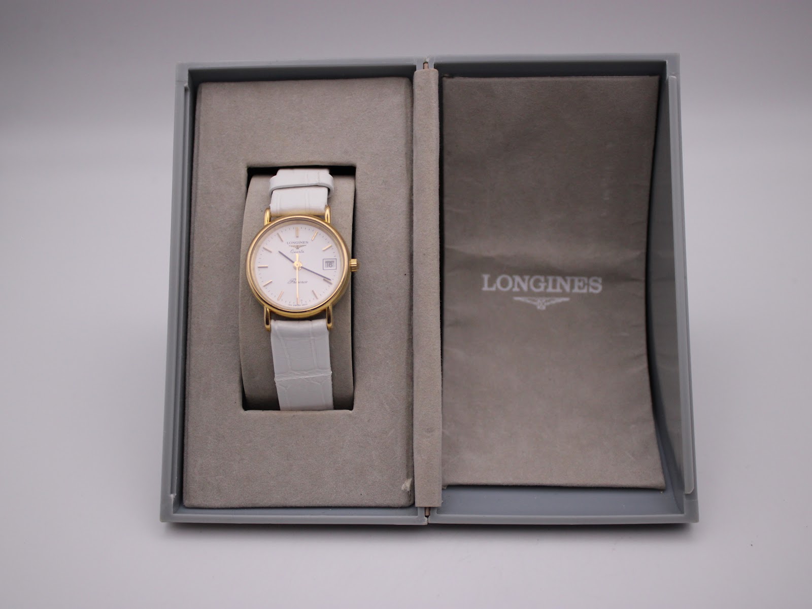 Overhead view of the Longines Presence watch resting in its open original grey box.