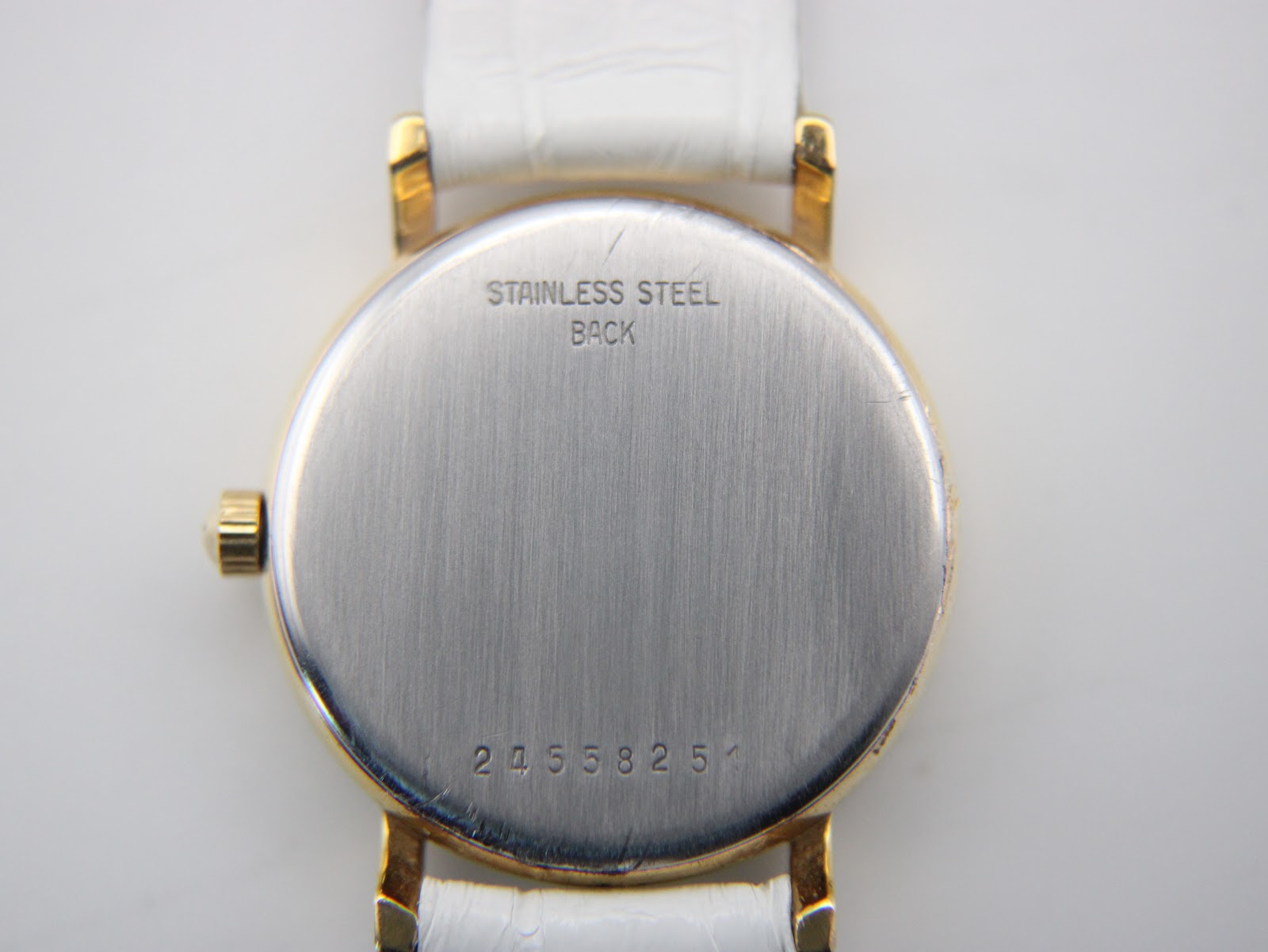 Detailed view of the brushed stainless steel case back of the Longines Presence, showing "STAINLESS STEEL BACK" and the serial number.