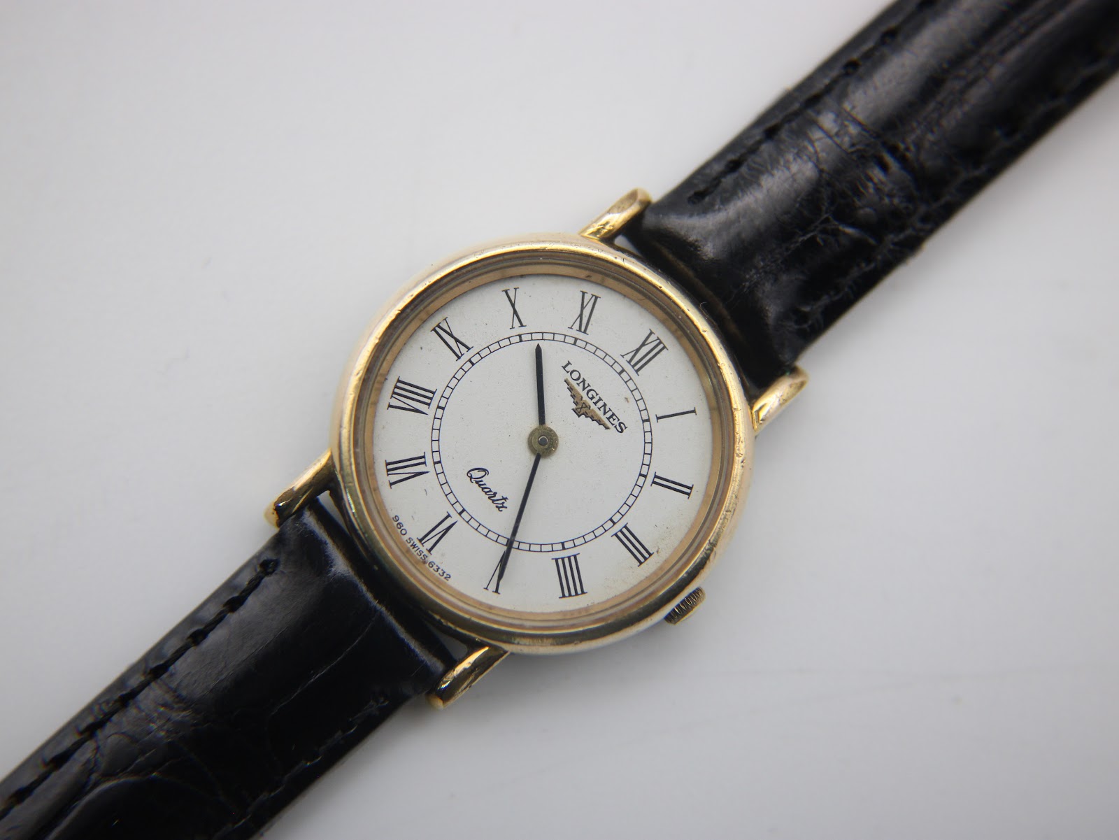Slightly angled close-up of the Longines watch dial and upper strap, emphasising the white dial and crisp Roman numerals.
