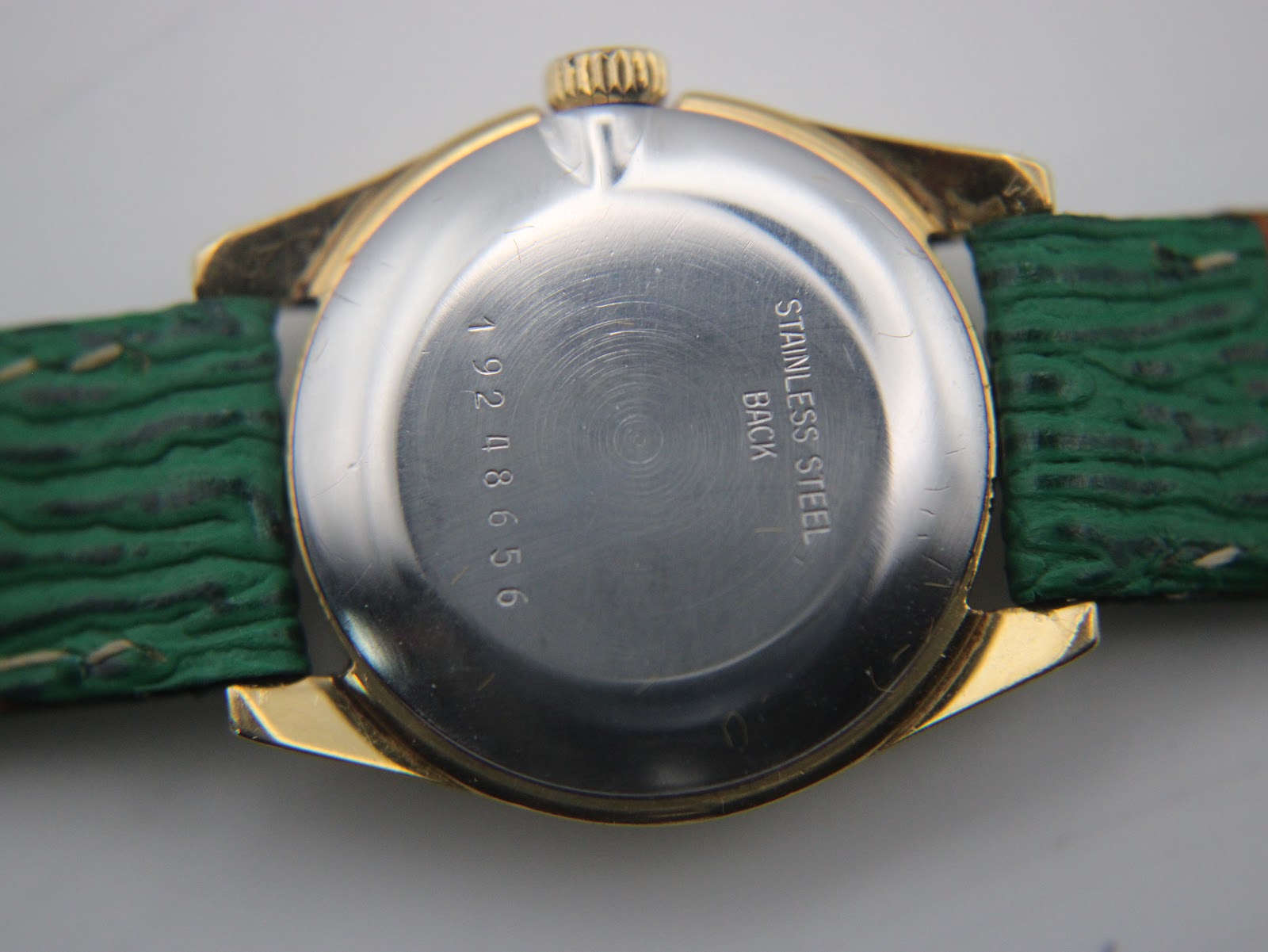 Macro shot of the Longines watch stainless steel case back, revealing the serial number '19248656' and 'Stainless Steel Back'.