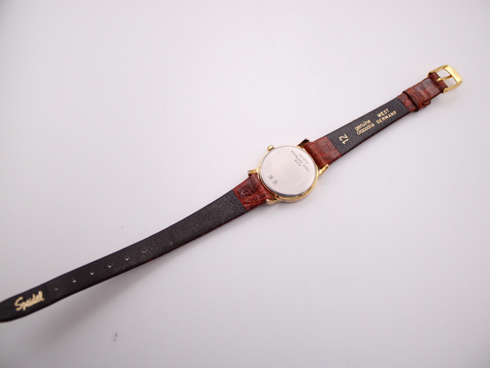 Underside view of the watch and strap, showing the case back, strap lining with 'Speidel', 'genuine lizard', and 'WEST GERMANY' markings.