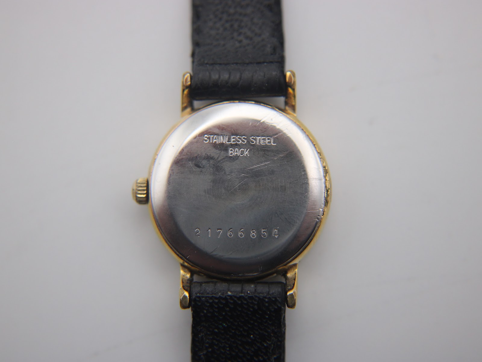 Rear view of the watch case back, with "STAINLESS STEEL BACK" and serial number "21766854" engraved.