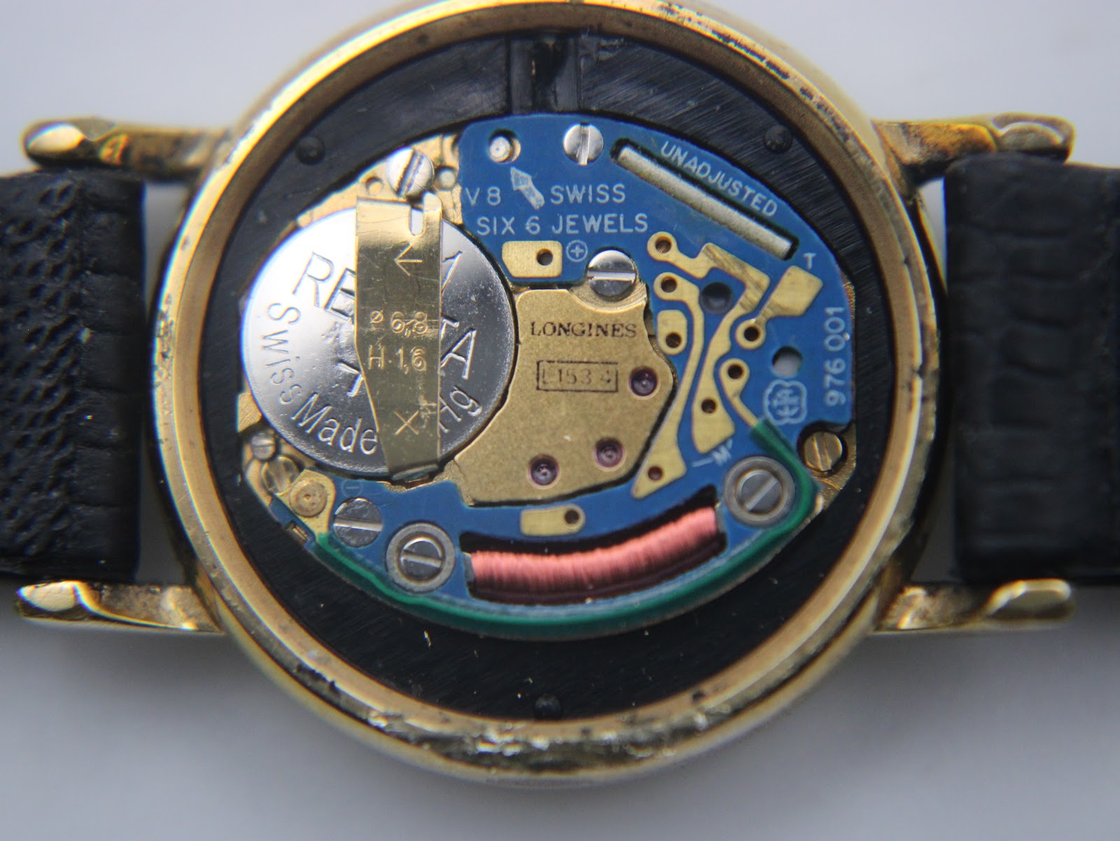 Detailed view of the Swiss quartz movement inside the watch, showing the Longines branding and six jewels.