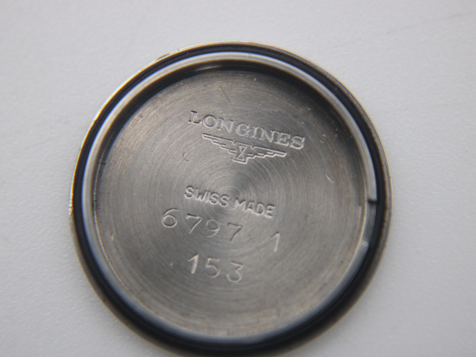 Inside of the stainless steel case back, showing "LONGINES SWISS MADE" and model numbers.