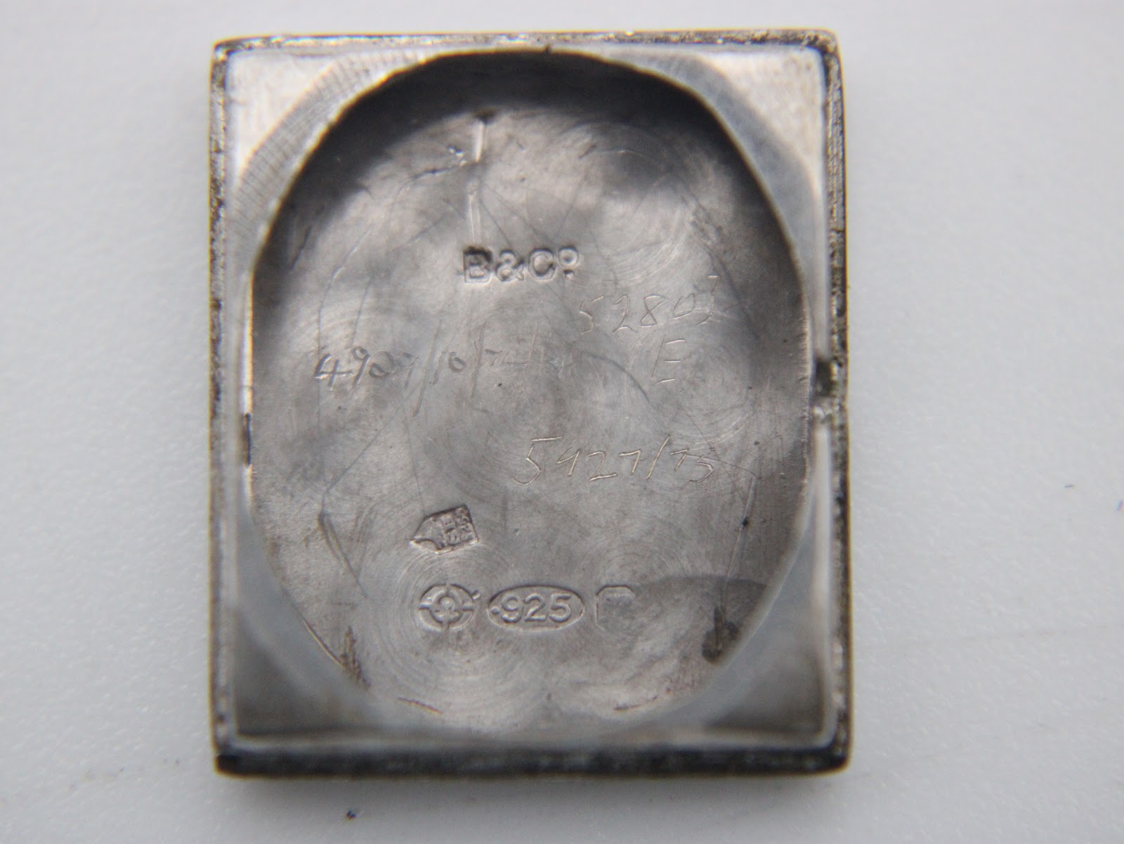 Interior of the sterling silver case back, showing the 'B&Co' mark, '925' stamp, and other engravings.