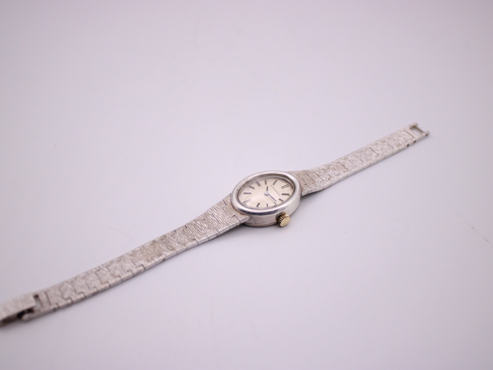 Overhead view of the full length of the Longines silver watch and its continuous textured 925 sterling silver bracelet.