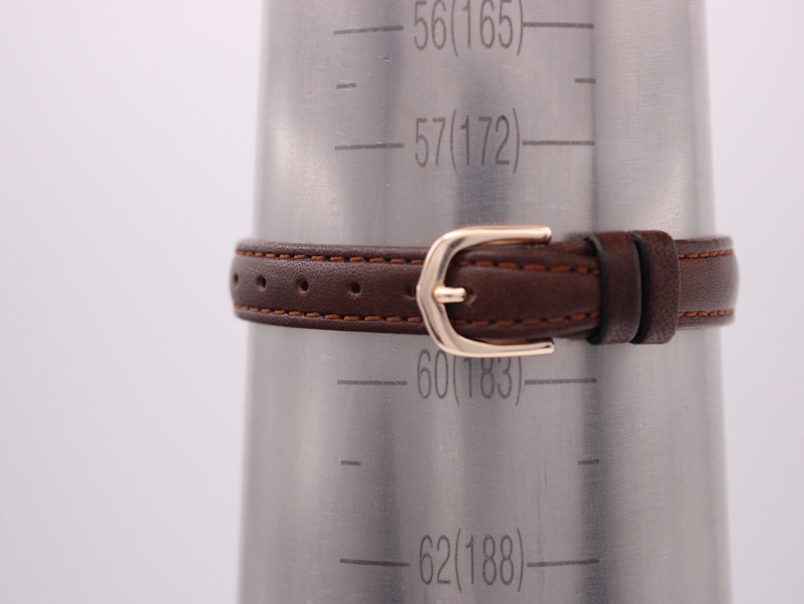 Brown leather watch strap shown on a wrist sizing gauge, indicating a wrist circumference range of approximately 15.5cm to 19.5cm.