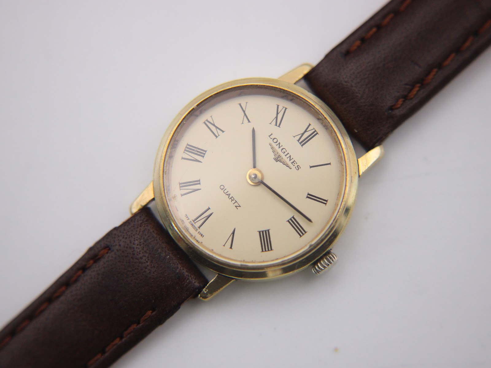 Close-up of the Longines cream dial with Roman numerals, Longines logo, 'Quartz' text, and 'Swiss Made' detail.
