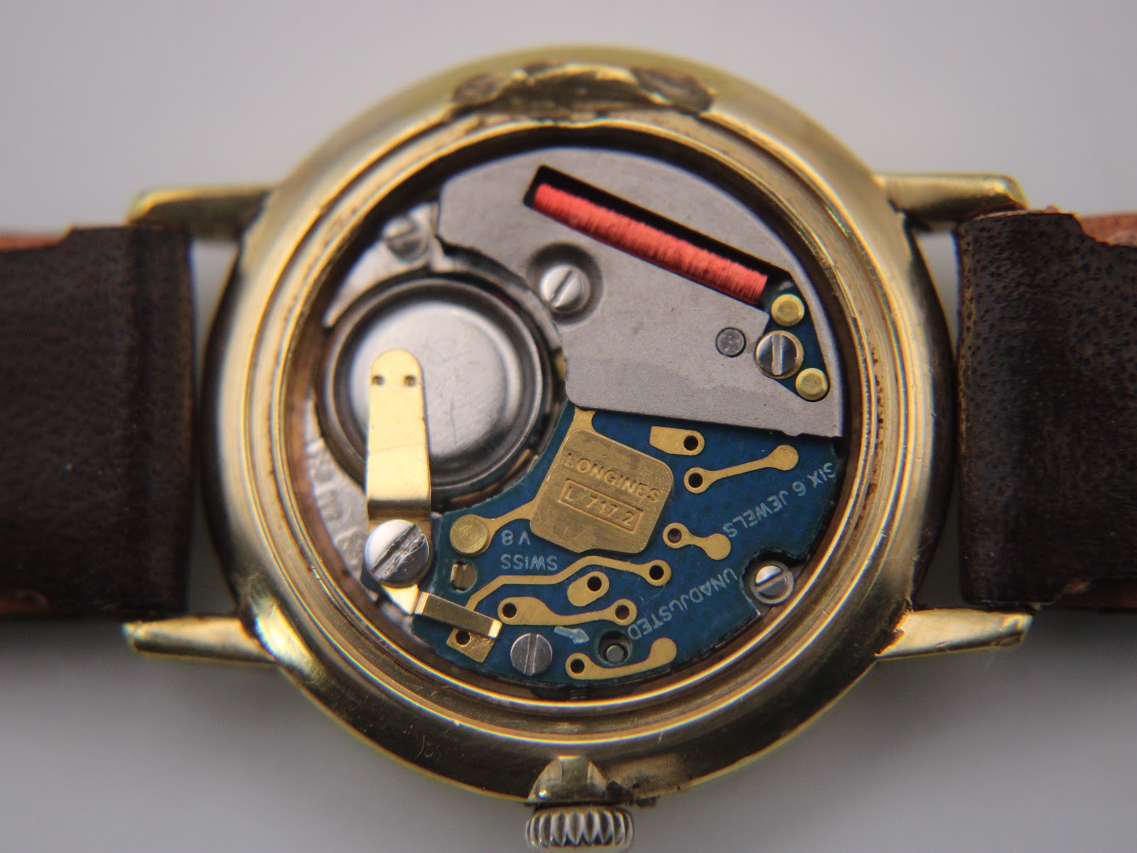 View of the Longines L717.2 Swiss quartz movement inside the watch case, showing components and 'SIX 6 JEWELS UNADJUSTED'.