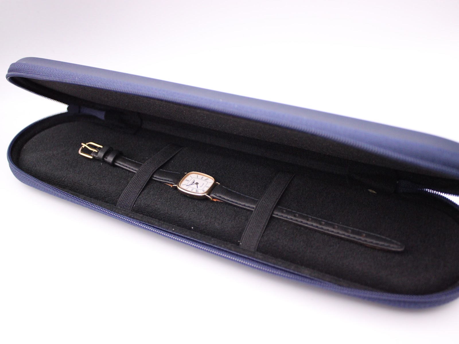 The Longines watch neatly placed inside its original navy blue zip-up travel case.