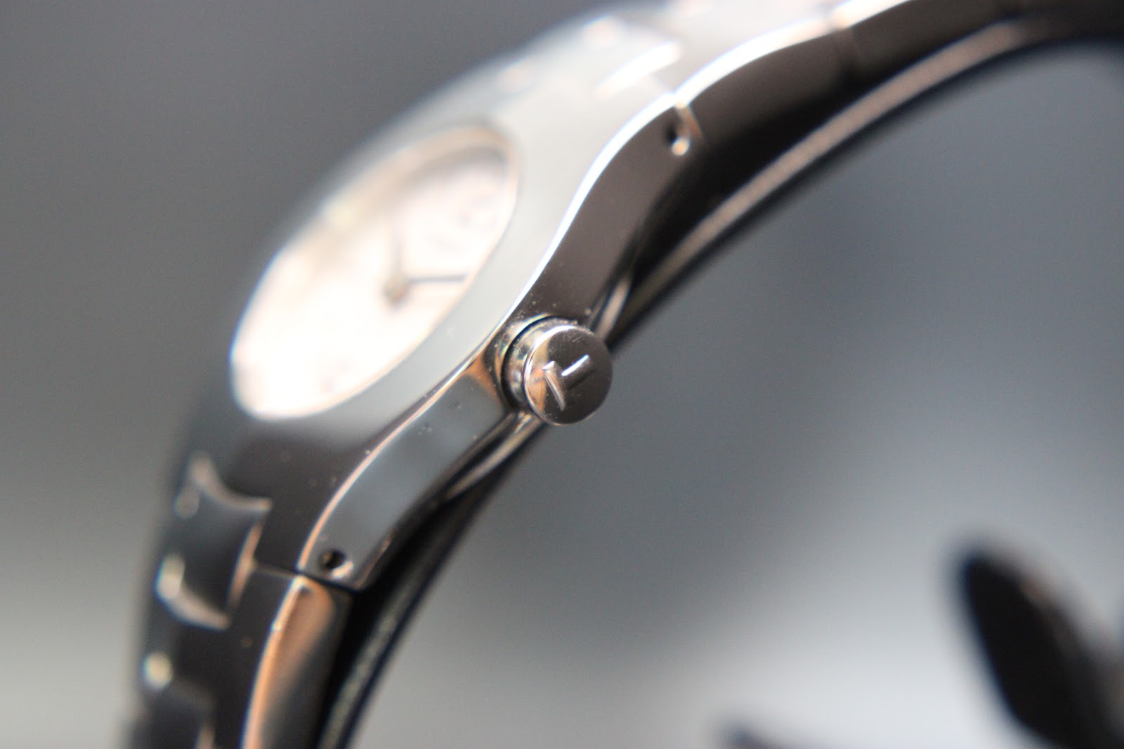 Close-up side view of the Tissot watch crown, showing its polished finish and integrated case design.