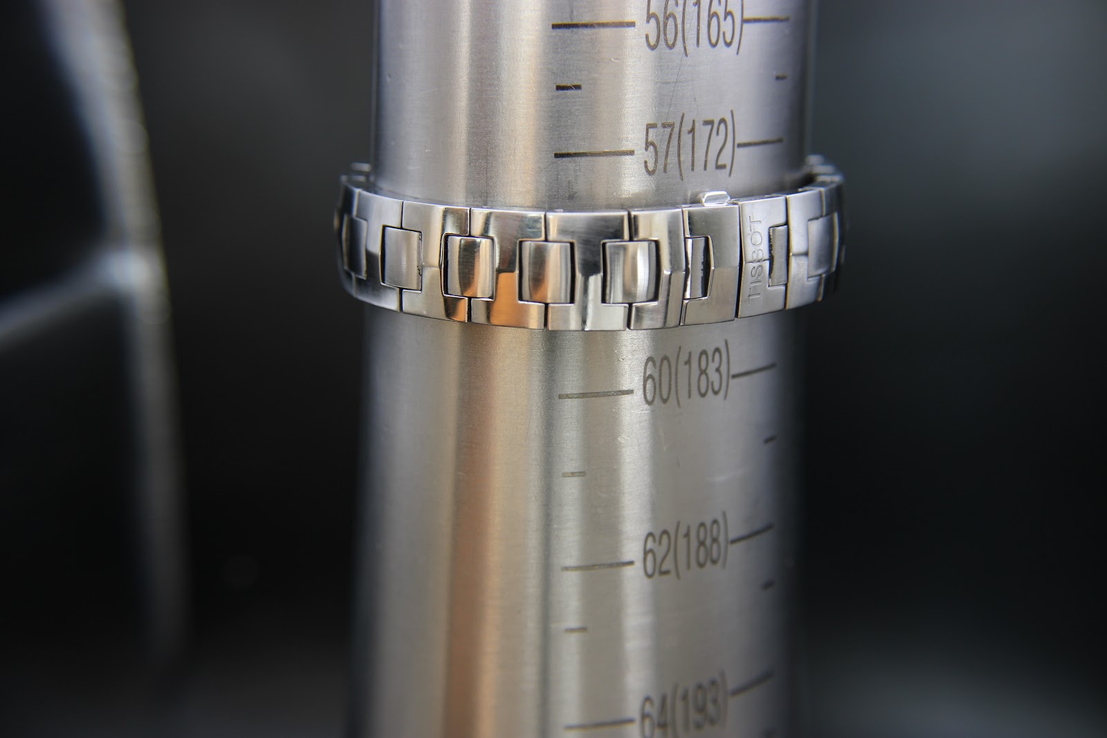 The Tissot watch bracelet wrapped around a wrist sizing gauge, indicating a wrist fit of approximately 160mm / 16cm.