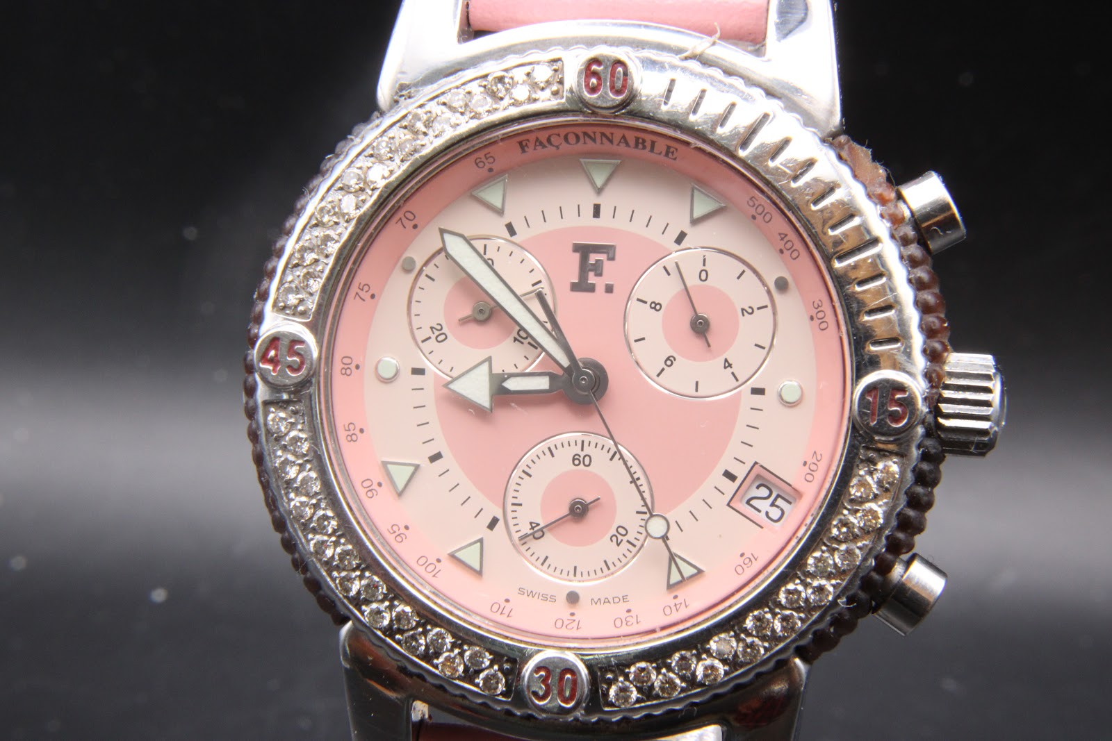 Close-up front view of the Façonnable watch dial, showing the pink face, three subdials, date window, and 'Façonnable Swiss Made' text.