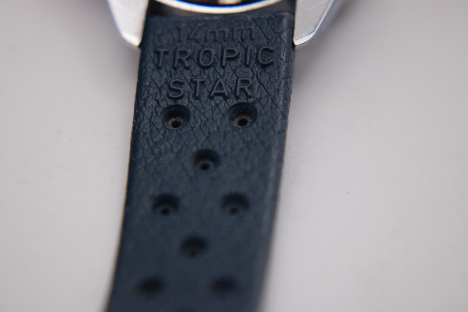 Close-up of the dark blue Tropic-style rubber strap, showing "14mm TROPIC STAR" embossed text.