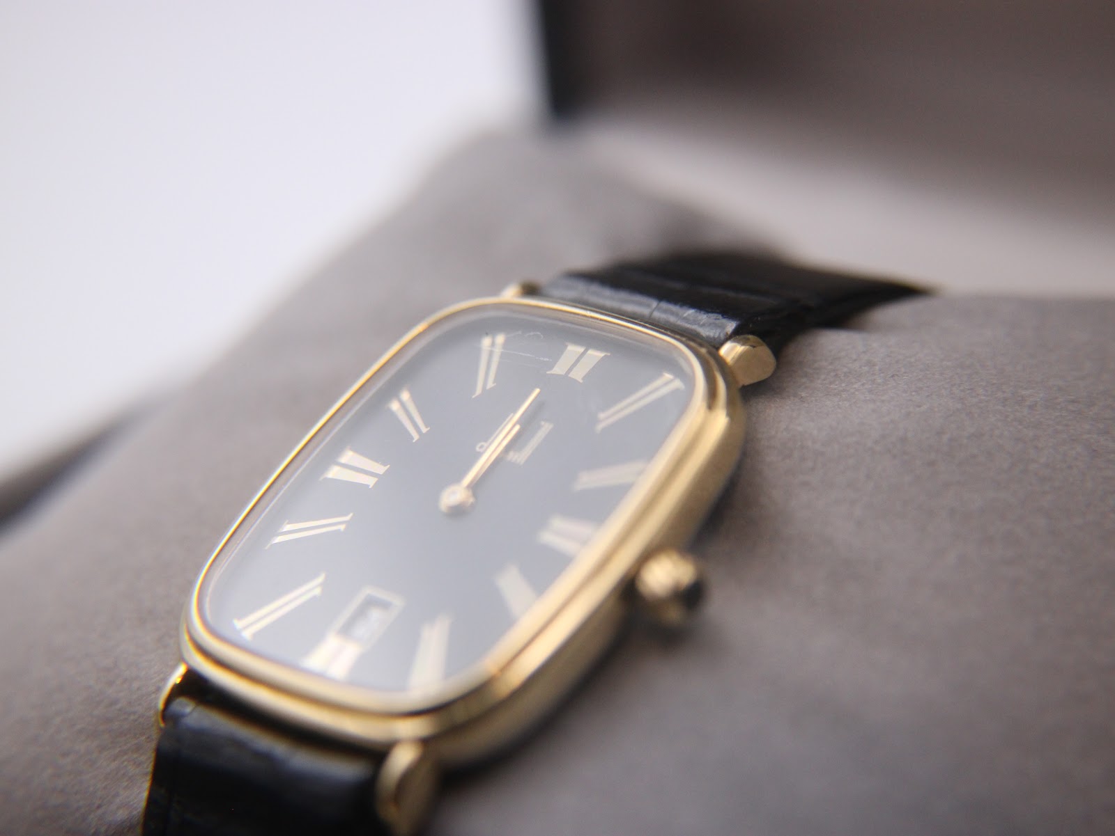 Angled view of the Dunhill watch in its original box, focusing on the dial and crystal with visible hairline scratches.
