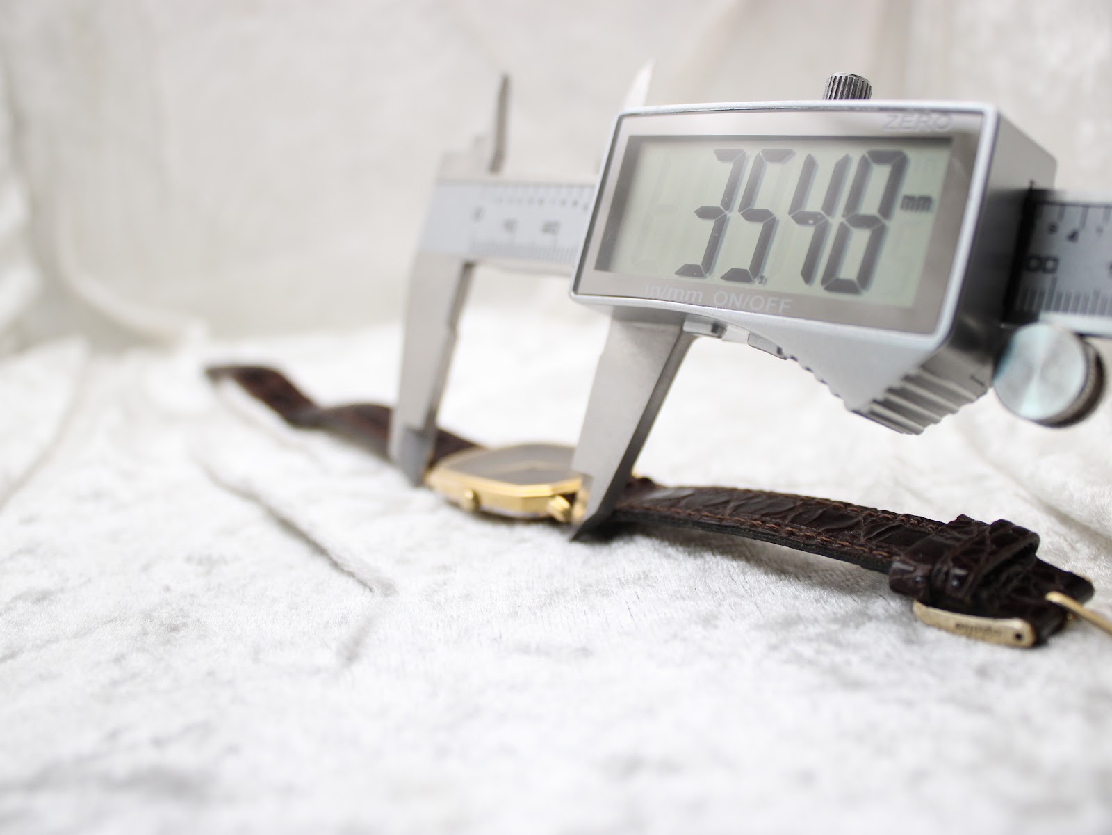 Digital caliper measuring the watch case height (lug-to-lug), displaying a precise reading of 35.48mm.