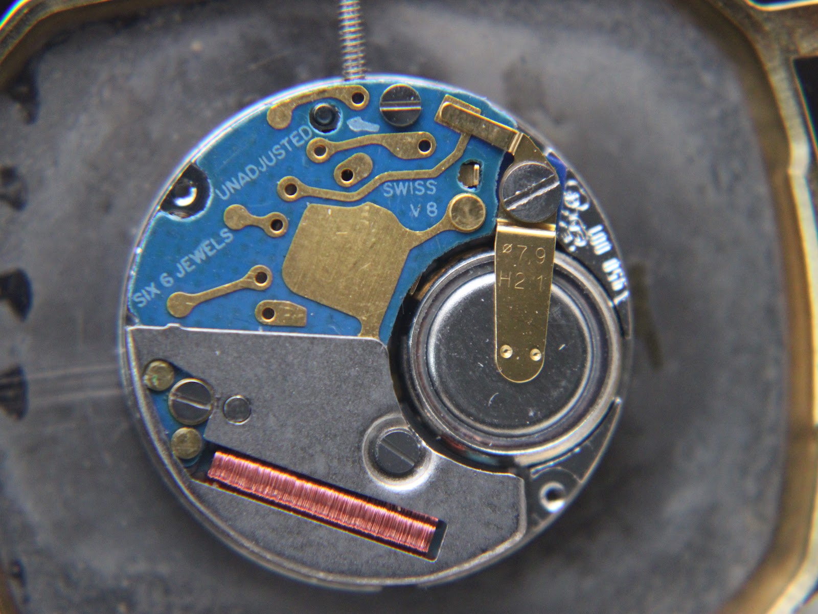 Close-up of the Swiss ESA 950.001 quartz movement inside the case, with 'SIX 6 JEWELS SWISS V8' visible.
