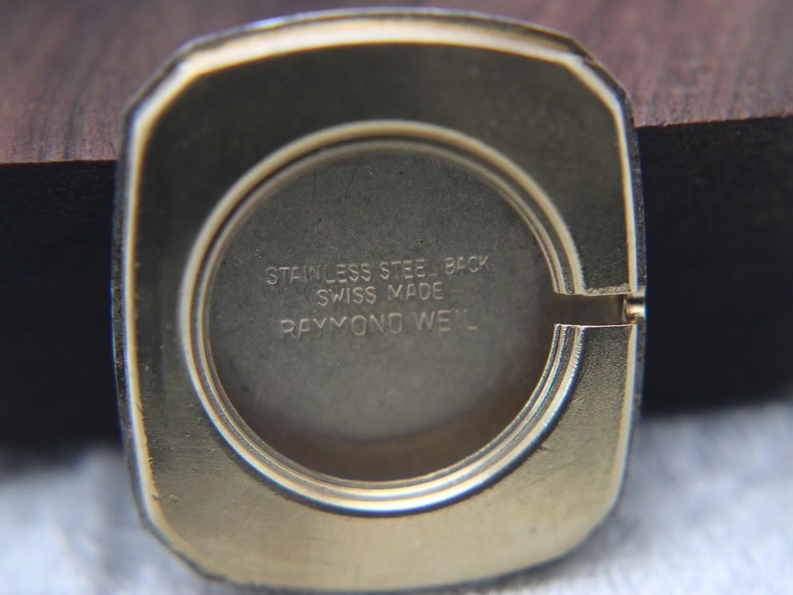 Interior of the case back showing 'STAINLESS STEEL BACK SWISS MADE RAYMOND WEIL' engraving.