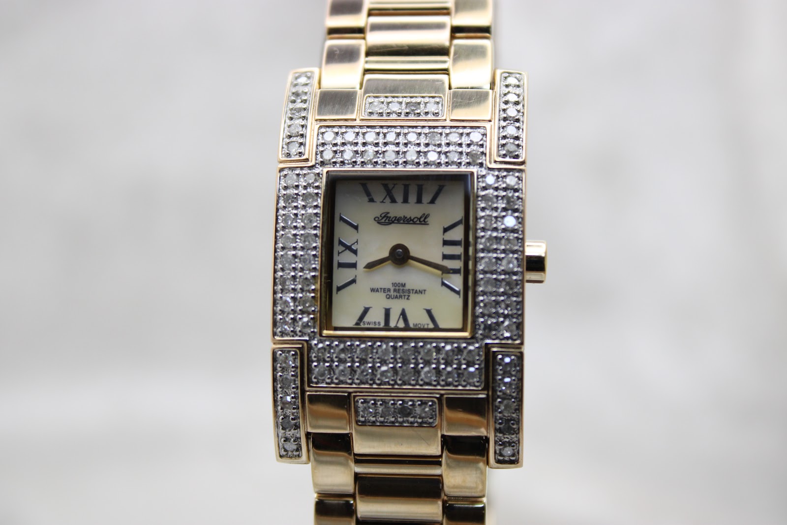 Front-on view of the Ingersoll Diamond watch on a black stand, featuring the mother-of-pearl dial with Roman numerals and crystal embellishments.
