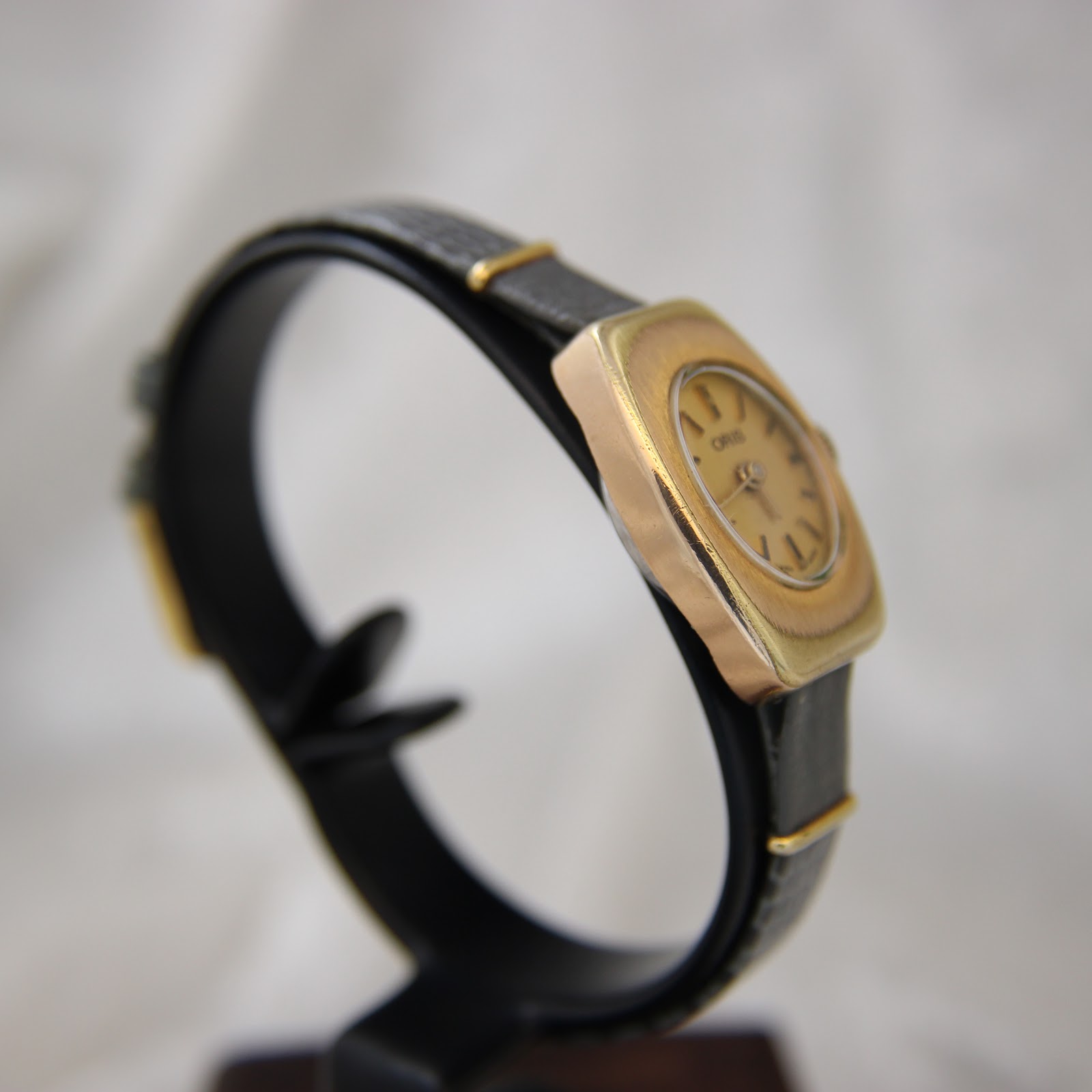 Detail of the black leather strap and pin buckle of the Oris watch.