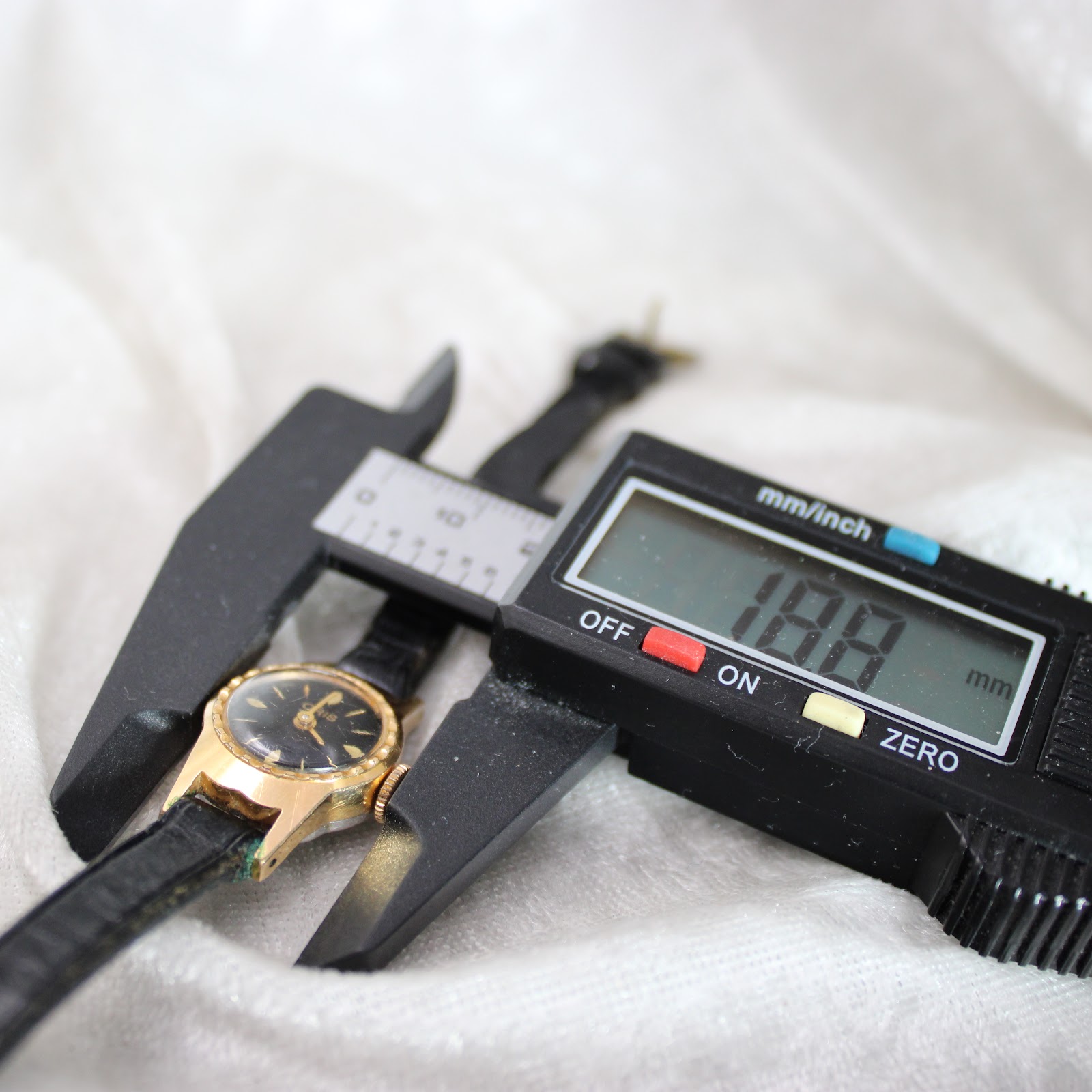 Digital caliper measuring the case of the vintage Oris watch, displaying a width of 18.8mm.
