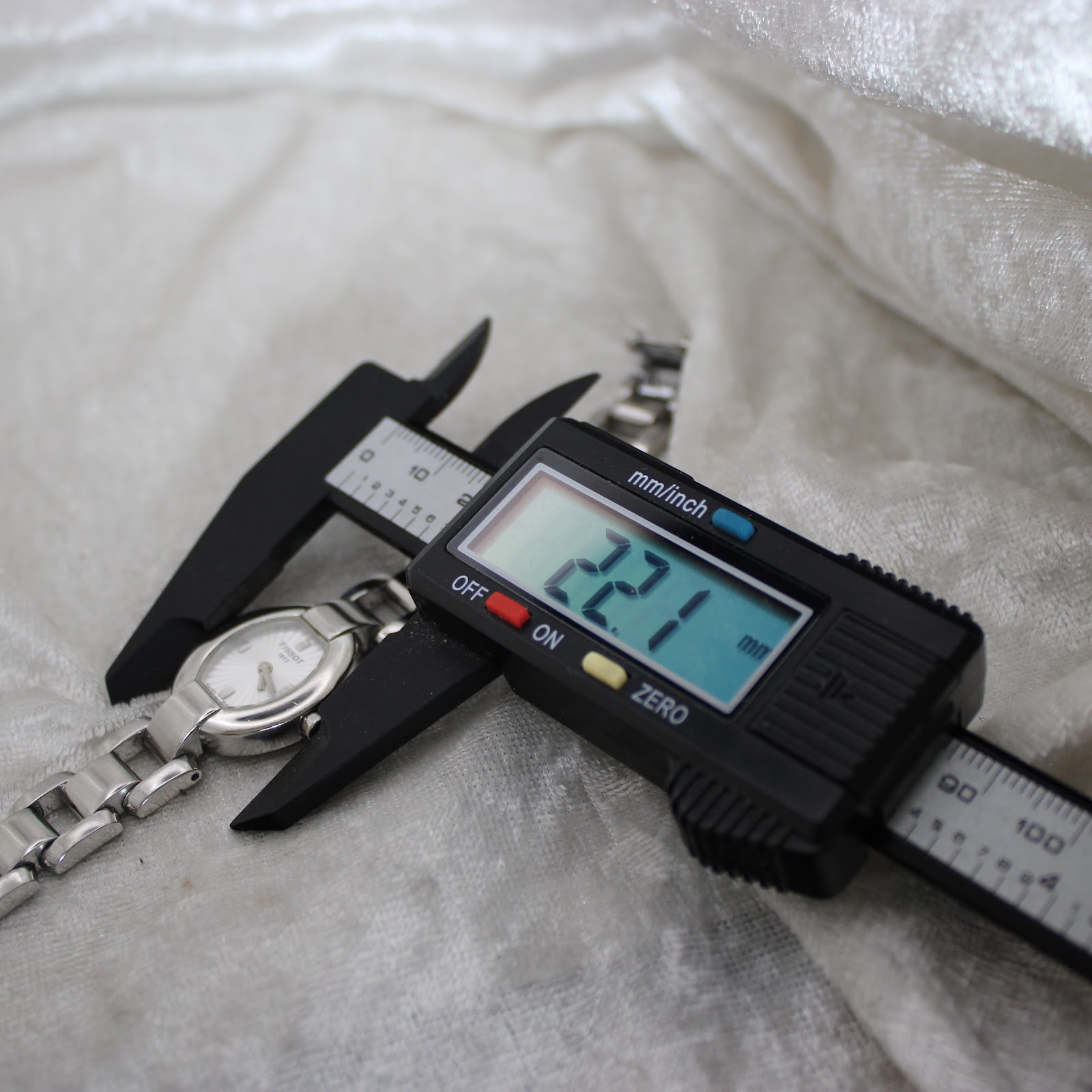 A digital caliper measuring the Tissot G332 watch case, displaying a precise width of 22.1mm.