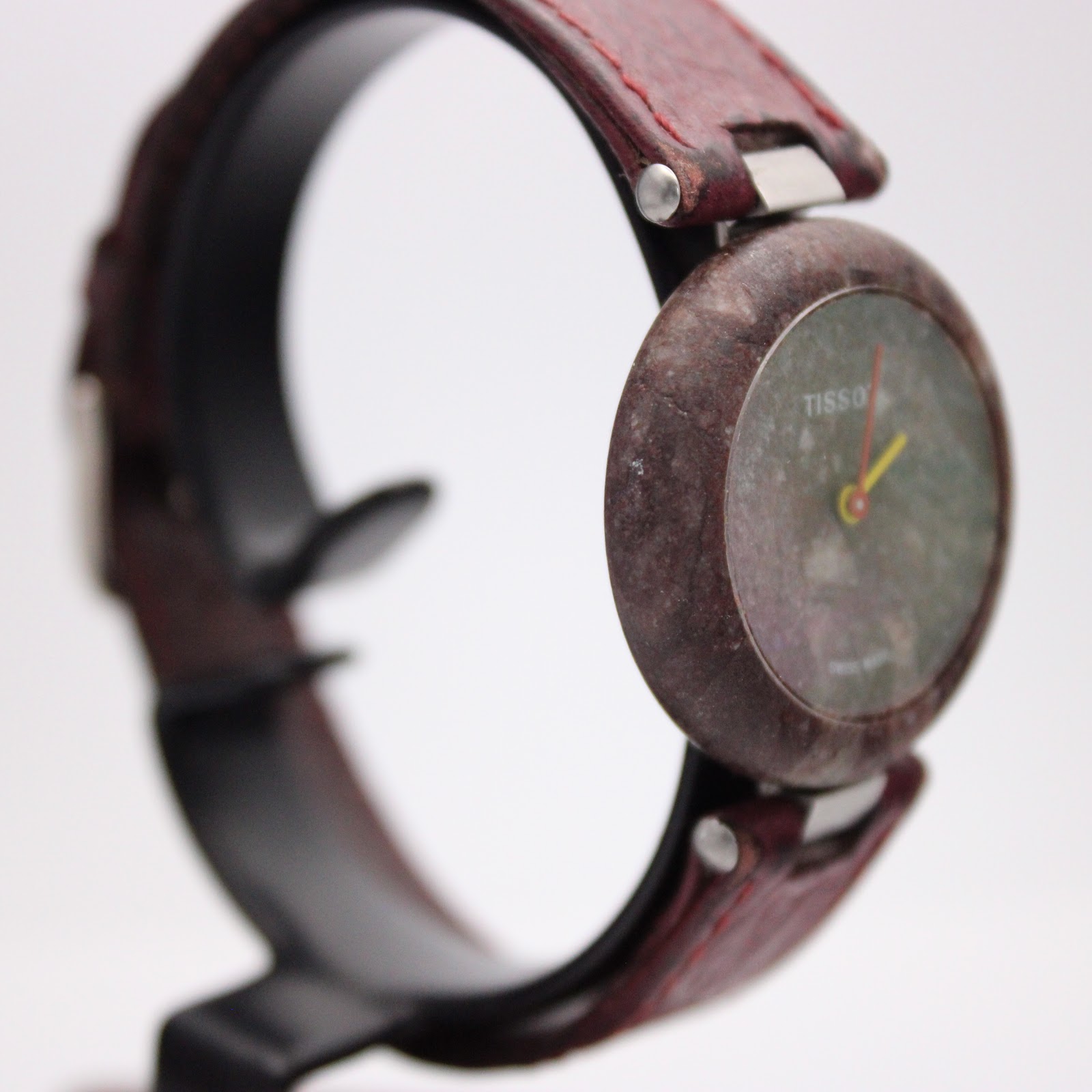 Another angled side view of the Tissot Rock Watch, showing the minimalist dial and the smooth, rounded profile of the stone case.