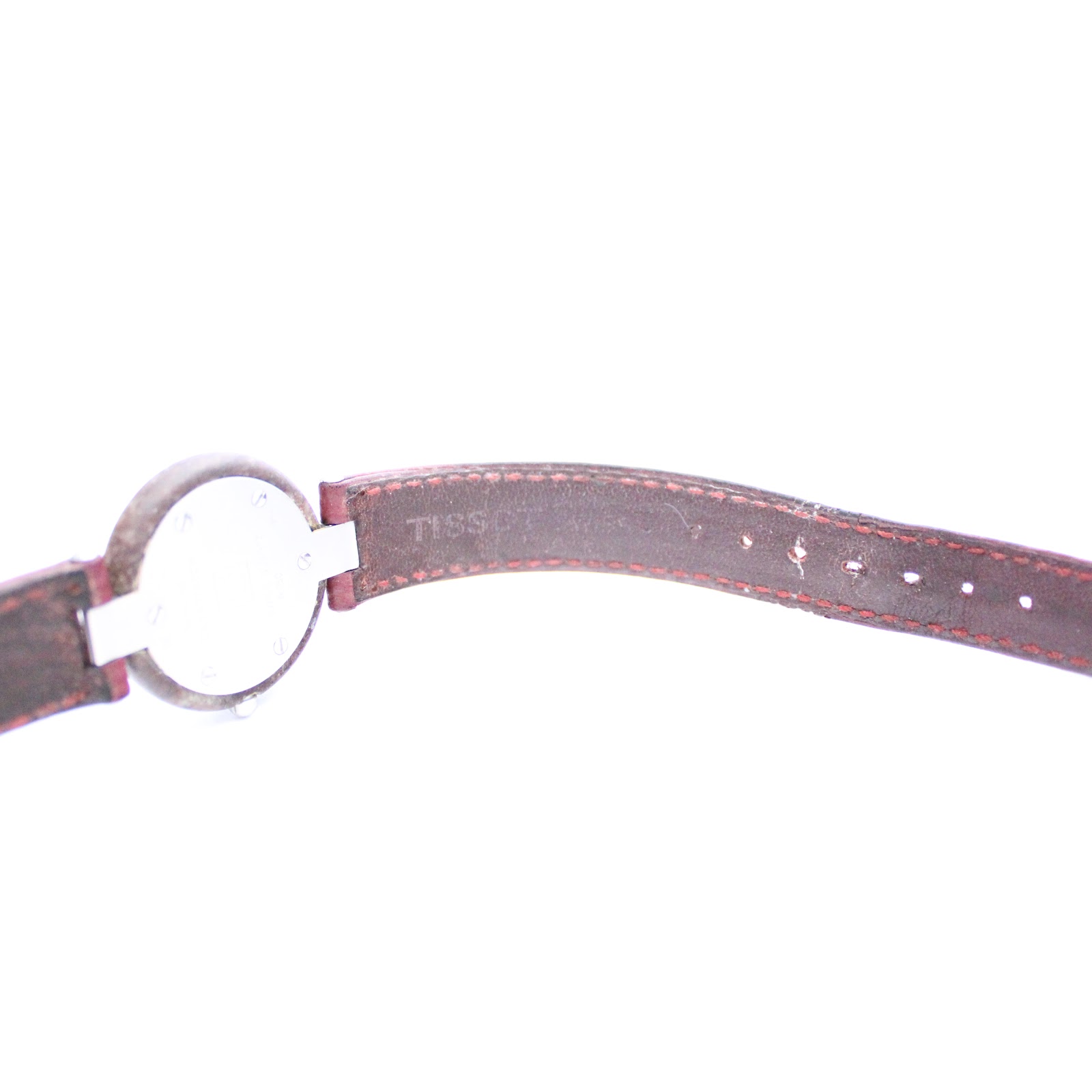 Close-up of the red leather strap's interior, showing the stitched detailing and some wear consistent with age.