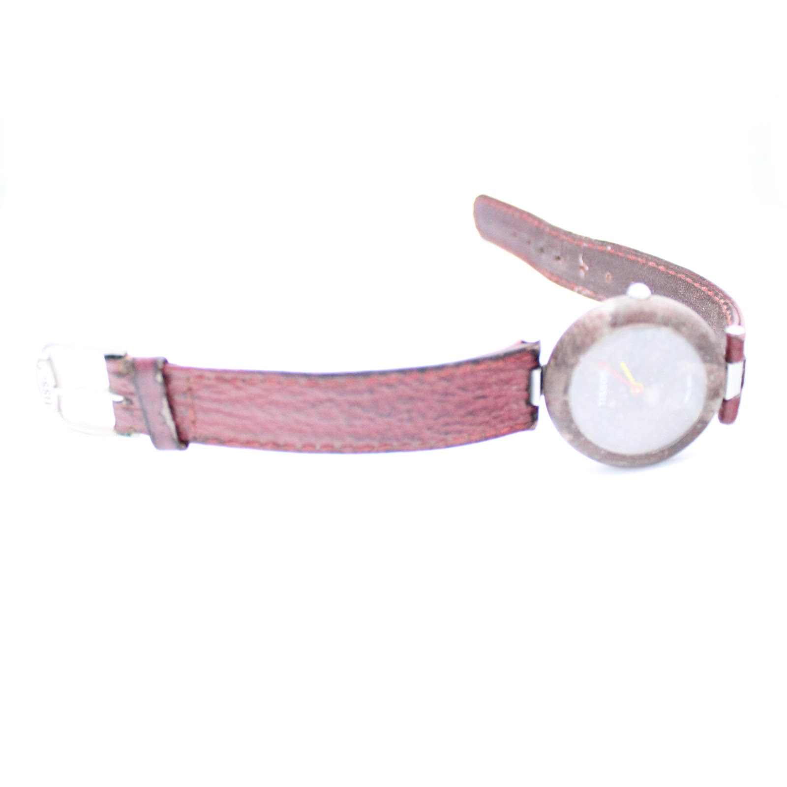 Side profile view of the Tissot Rock Watch and its red leather strap, laid flat.