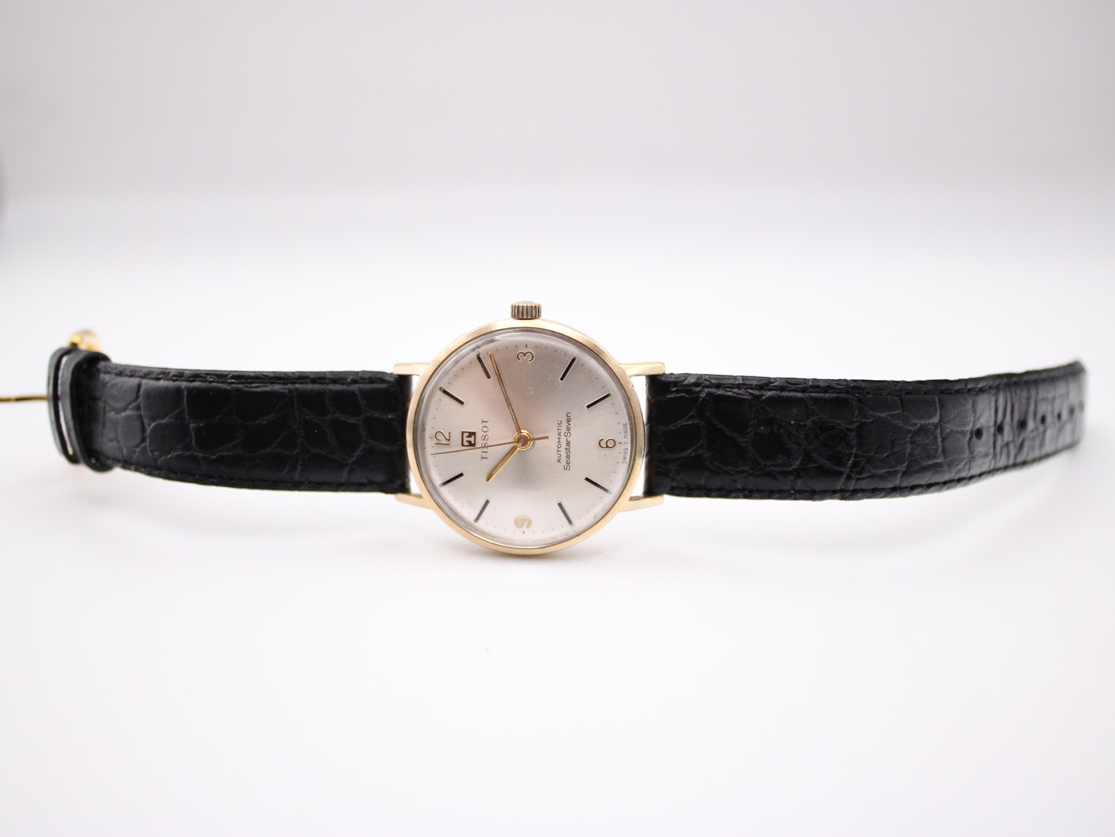Rear view of stainless steel case back and black leather strap.