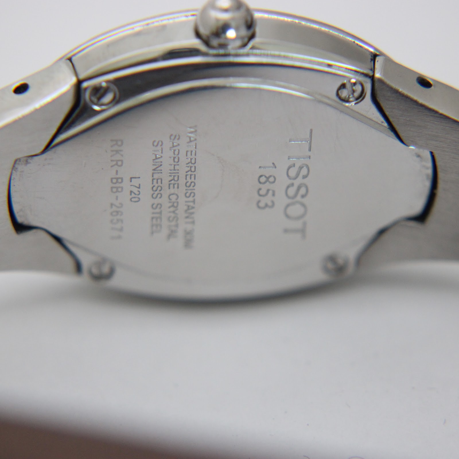 Close-up of the Tissot L720 case back, engraved with brand, model, water resistance, and 'stainless steel'.
